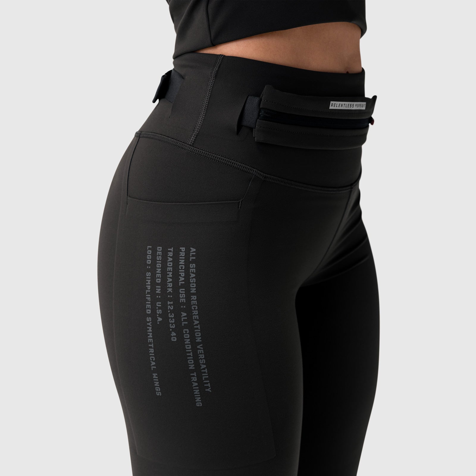 W030 Lycra 3-in-1 legging in black, worn by model showing side view with utility pocket detail