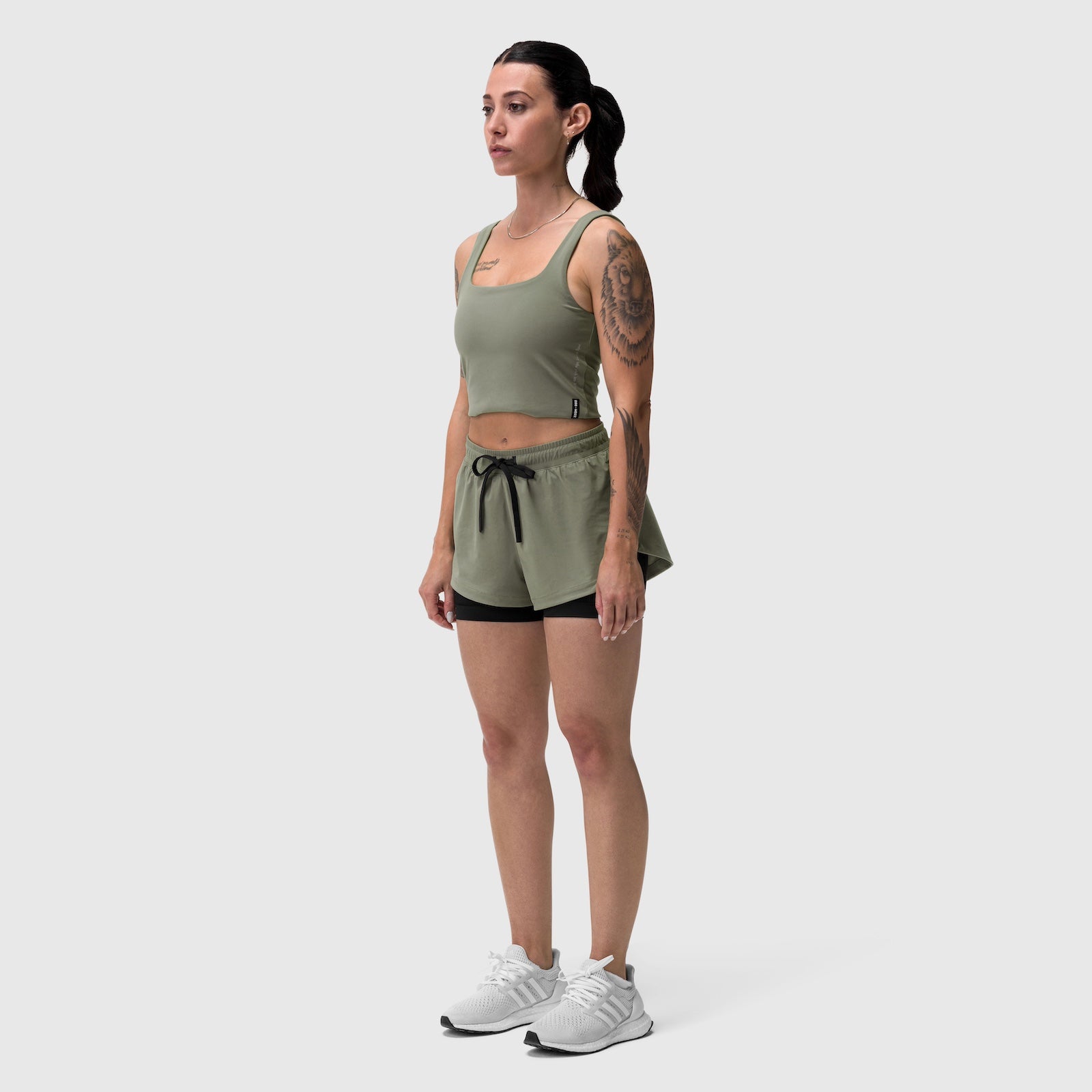 W025 Tetra-Lite Liner Short in sage, worn by model standing in profile view