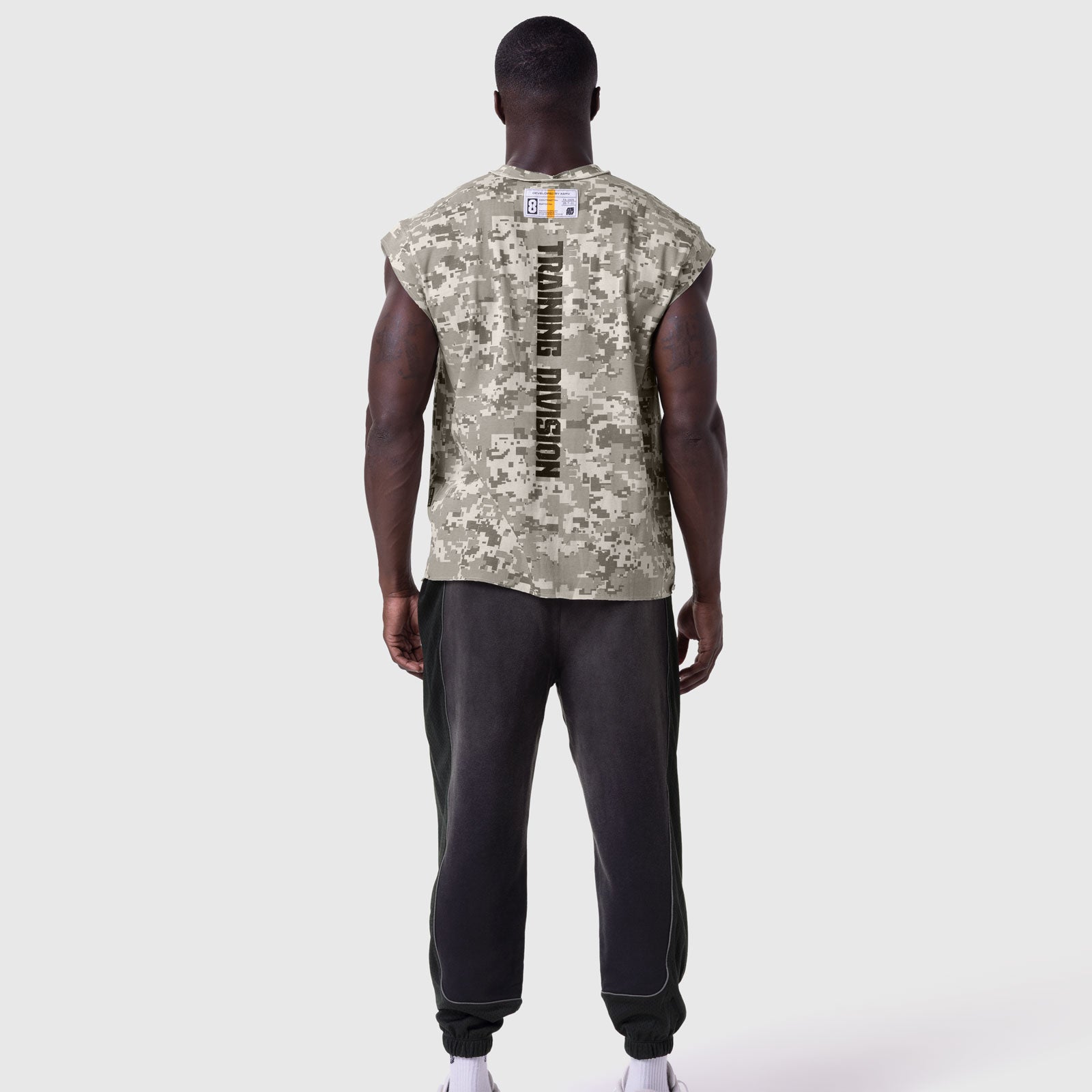 Tech Essential Cap Shoulder Cutoff in digital camo, model back view wearing with black joggers