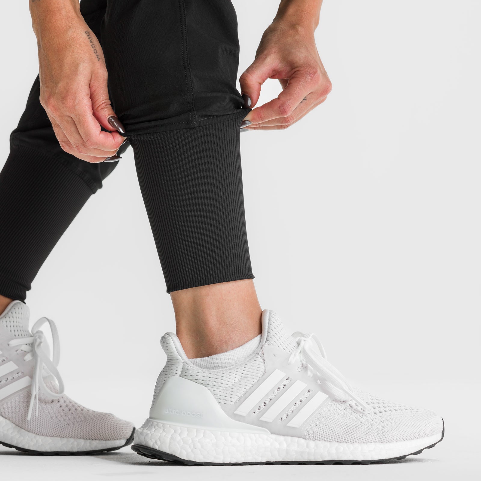 Black high rib jogger worn with white sneakers, front detail view