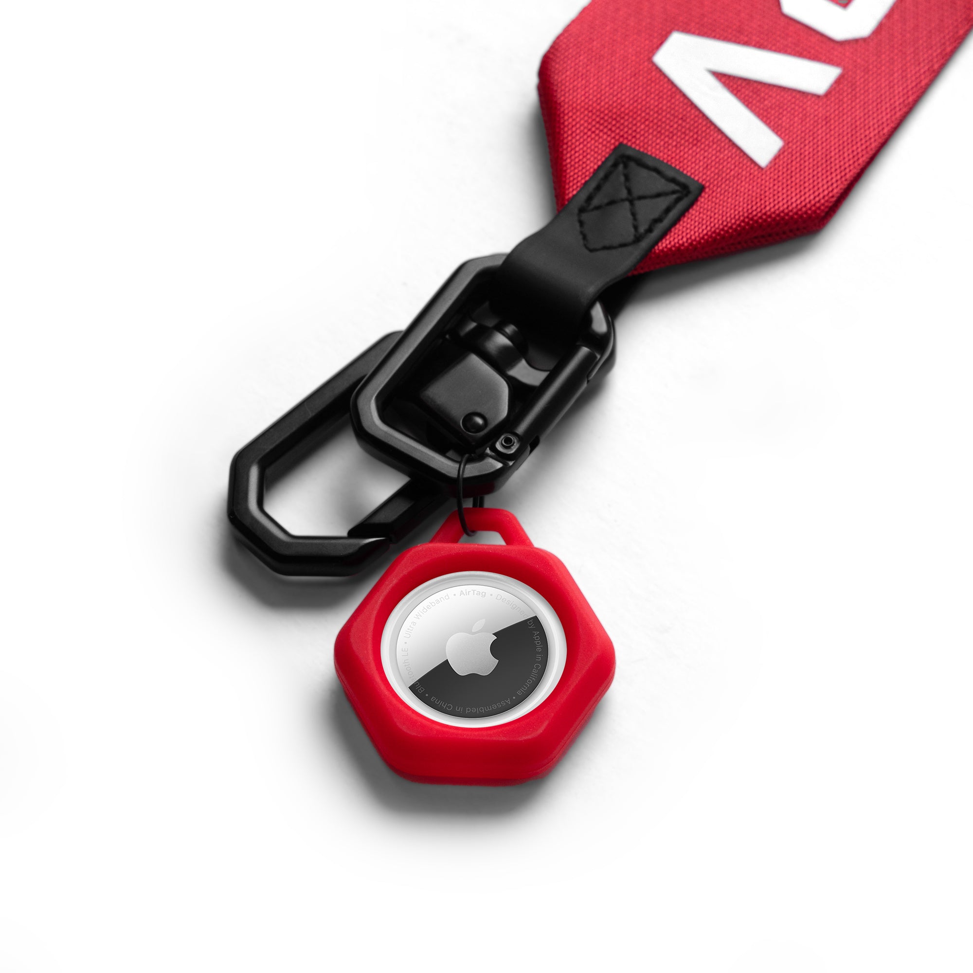 AirTag Lanyard Keychain in red with black carabiner and hexagonal case, top view