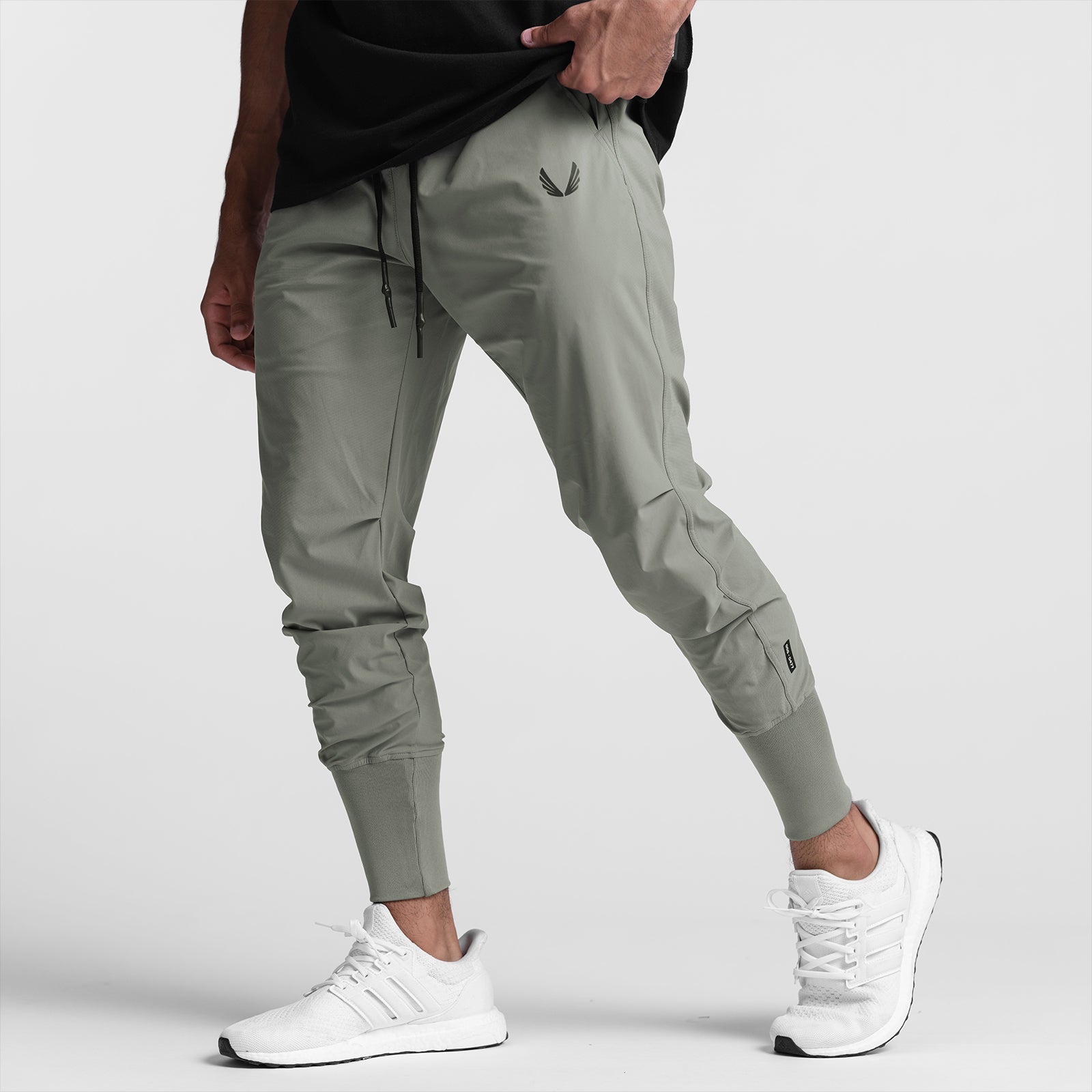 Tetra-Lite High Rib Jogger in sage worn by model with white sneakers, side view