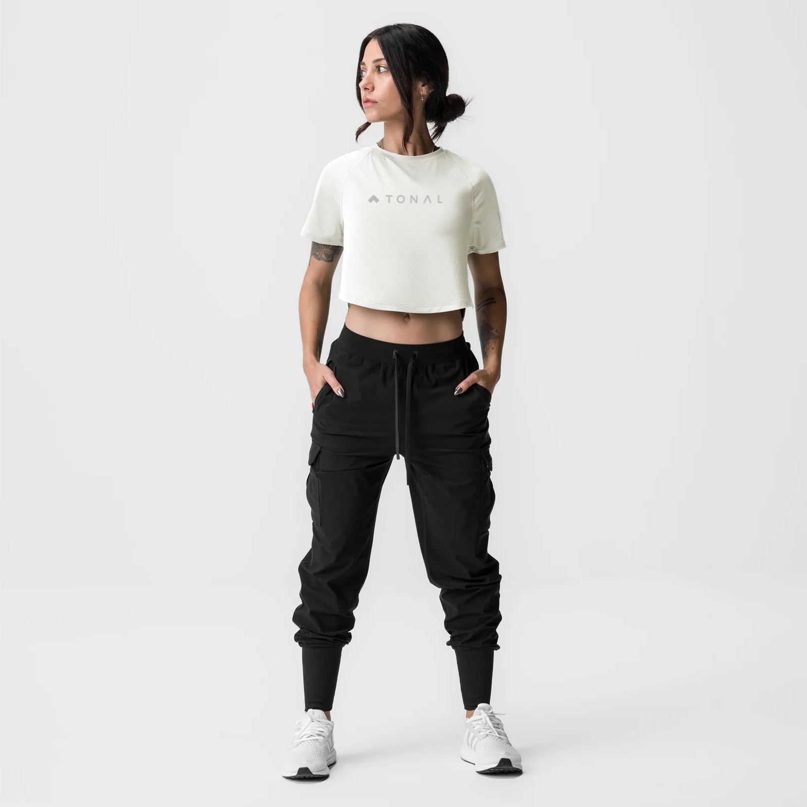 ASRV x Tonal Women's AeroSilver® Cropped Training Tee in ivory cream, worn with black cargo joggers