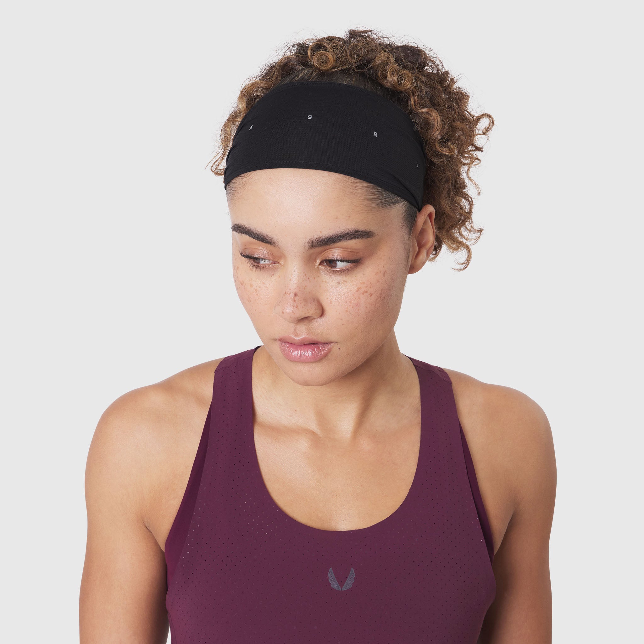 Ice-Skin Performance Headband in black worn by model with curly hair, front view