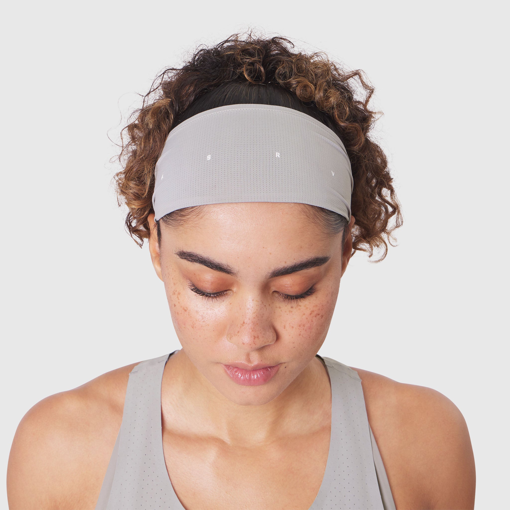 Ice-Skin™ Performance Headband in slate grey, worn by model during downward gaze