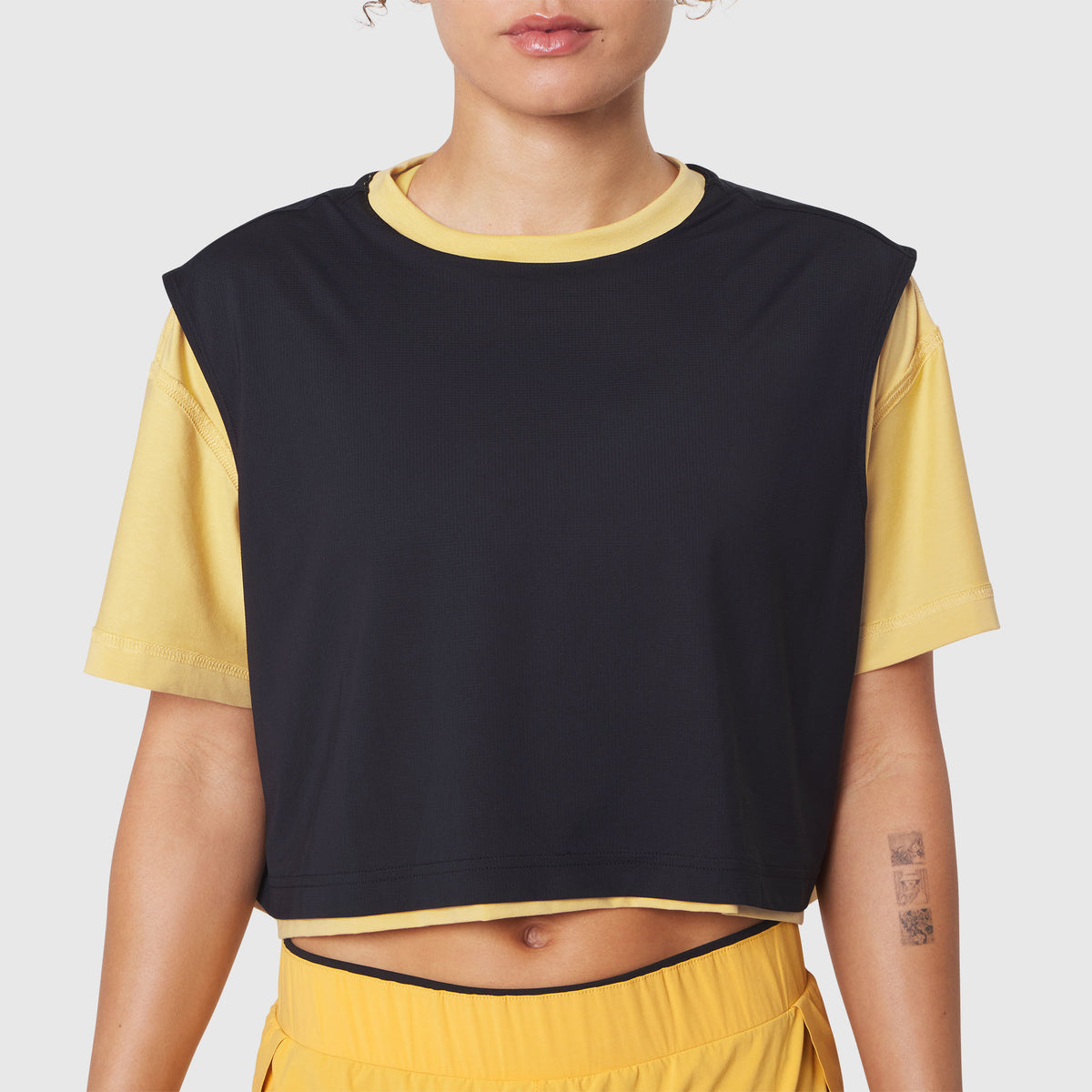 W082 Supima Ice-Skin Reversible Crop Tee in amber and black, front view on model