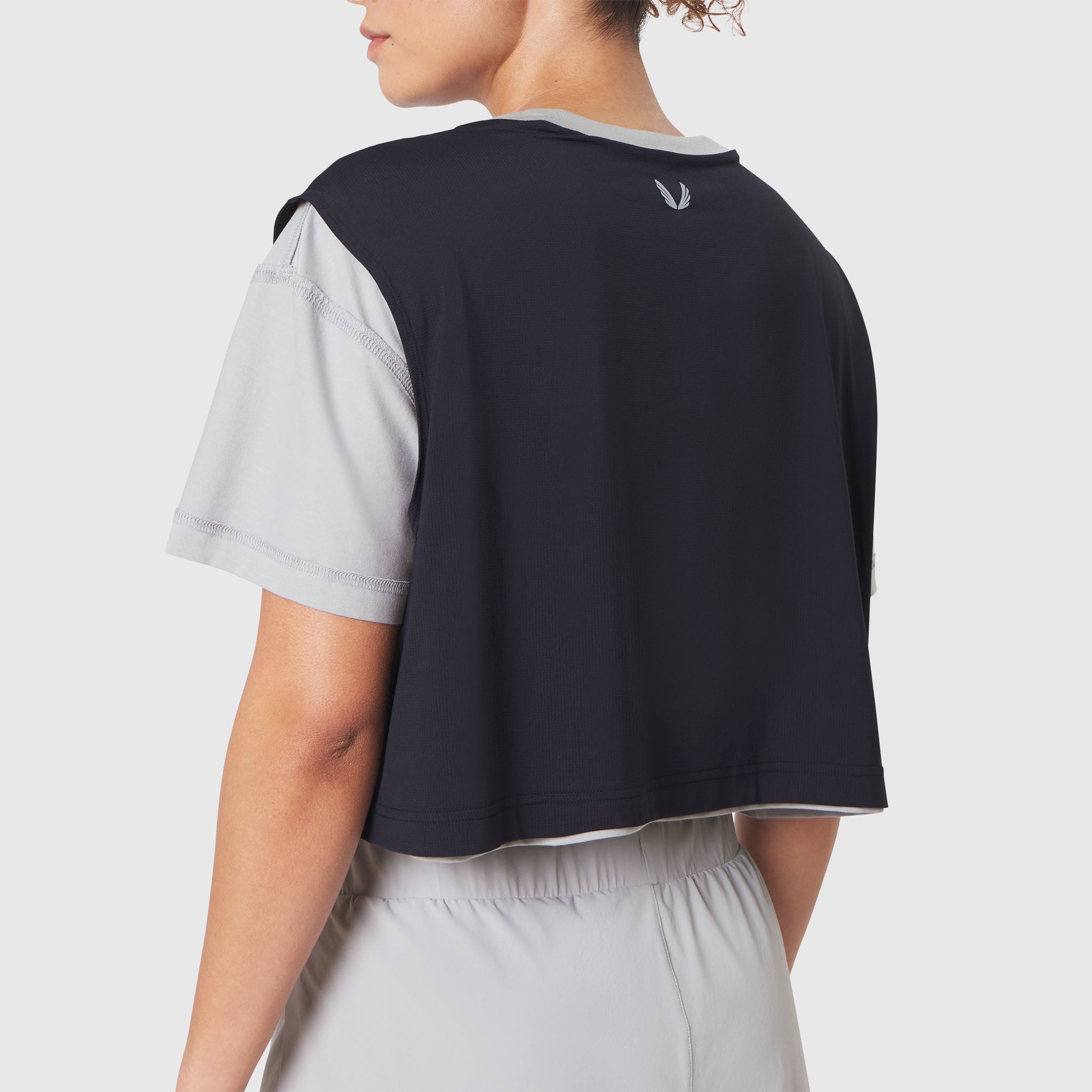 Reversible crop tee in slate grey and black, back view on model