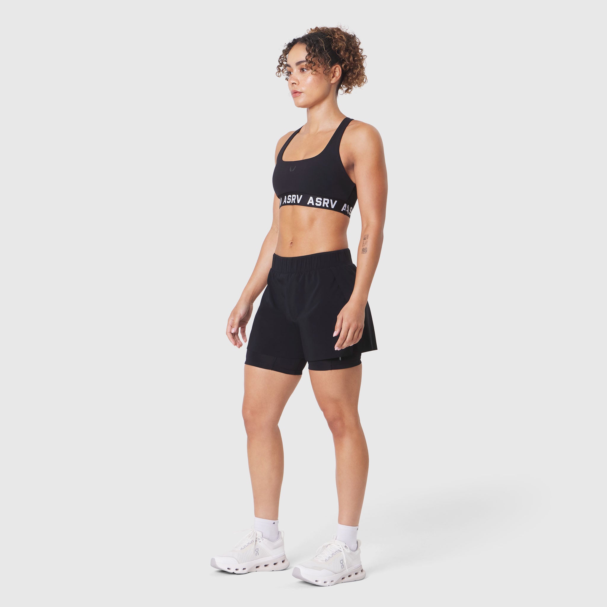 W083 LYCRA® ADAPTIV Racerback Sports Bra in black, worn with matching shorts
