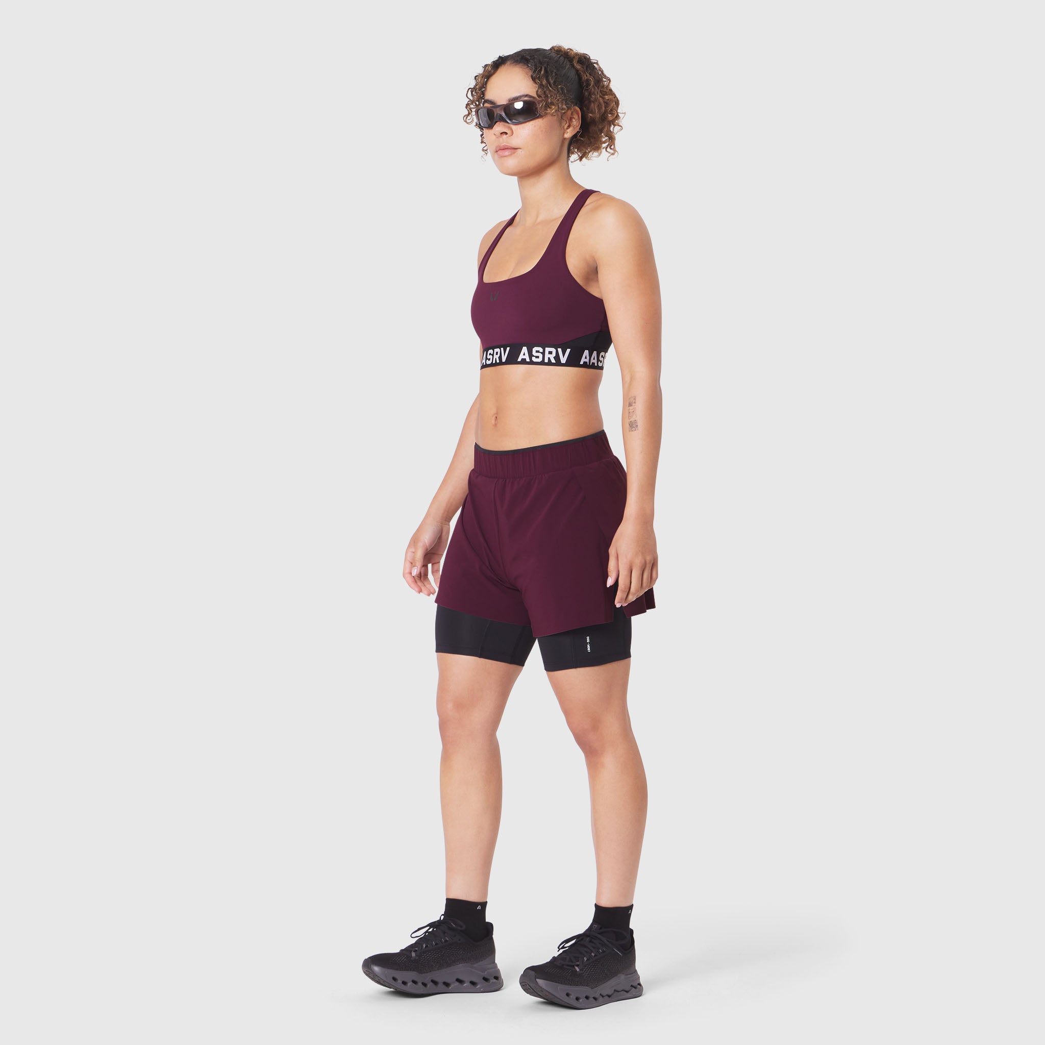 W083 LYCRA® ADAPTIV Racerback Sports Bra in Merlot, worn by model with matching shorts