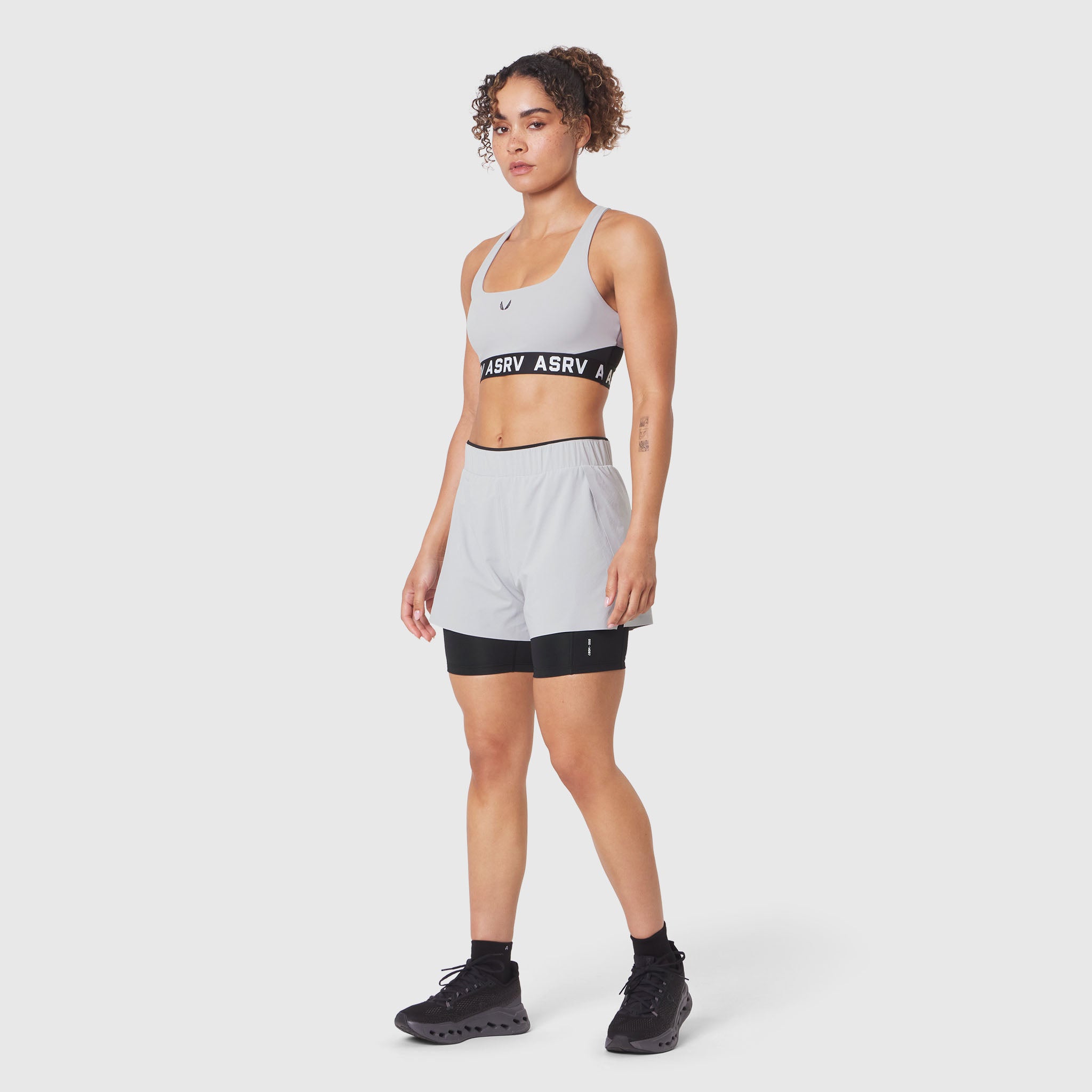 W083 LYCRA® ADAPTIV Racerback Sports Bra in Slate Grey, worn by model, front view