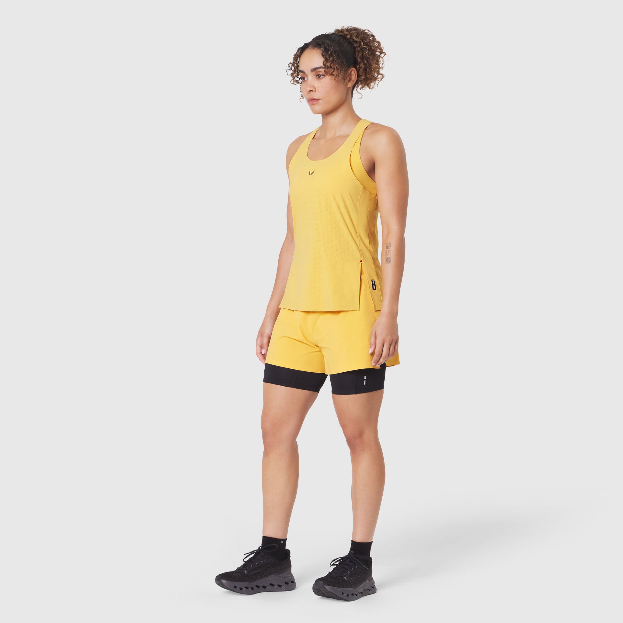 Aerotex Perforated Run Tank in Amber worn with matching shorts, side view
