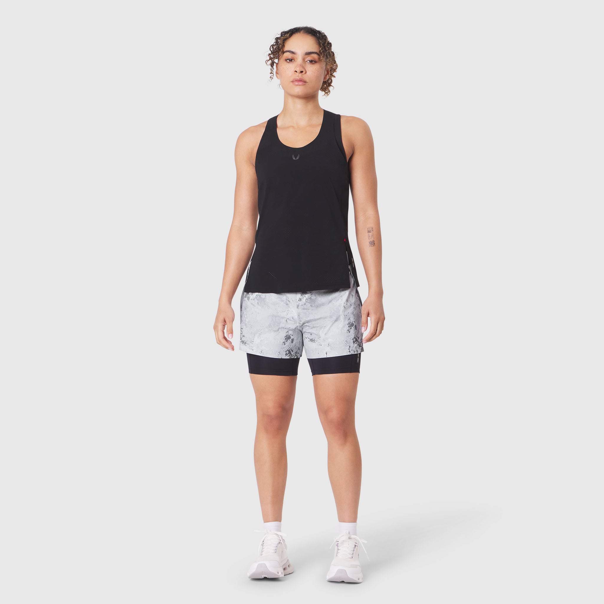 Aerotex™ Perforated Run Tank in black with patterned shorts, front view