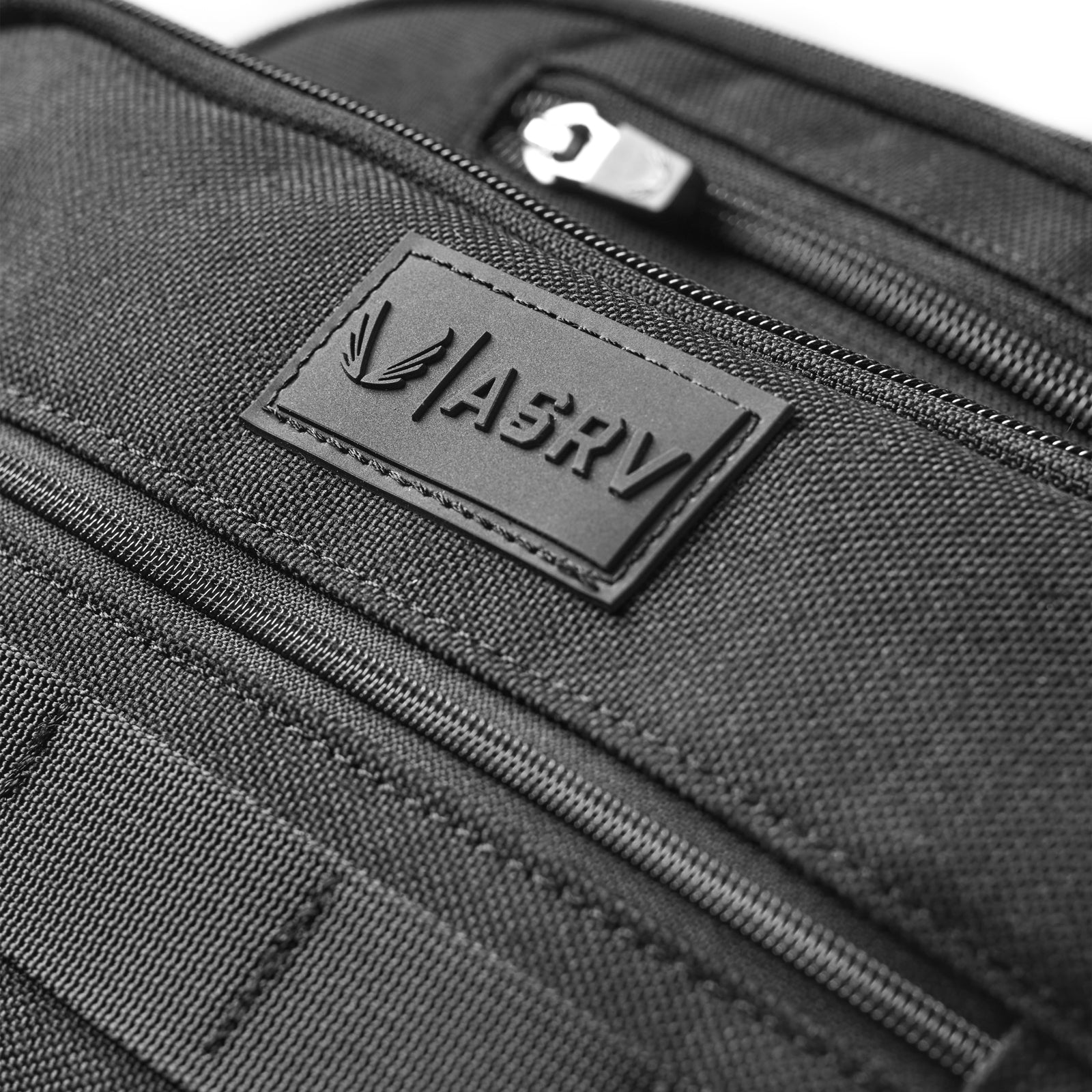 Flatlay of 0200 Cordura® Modular 2-in-1 Crossbody Backpack in black, detail view of brand label