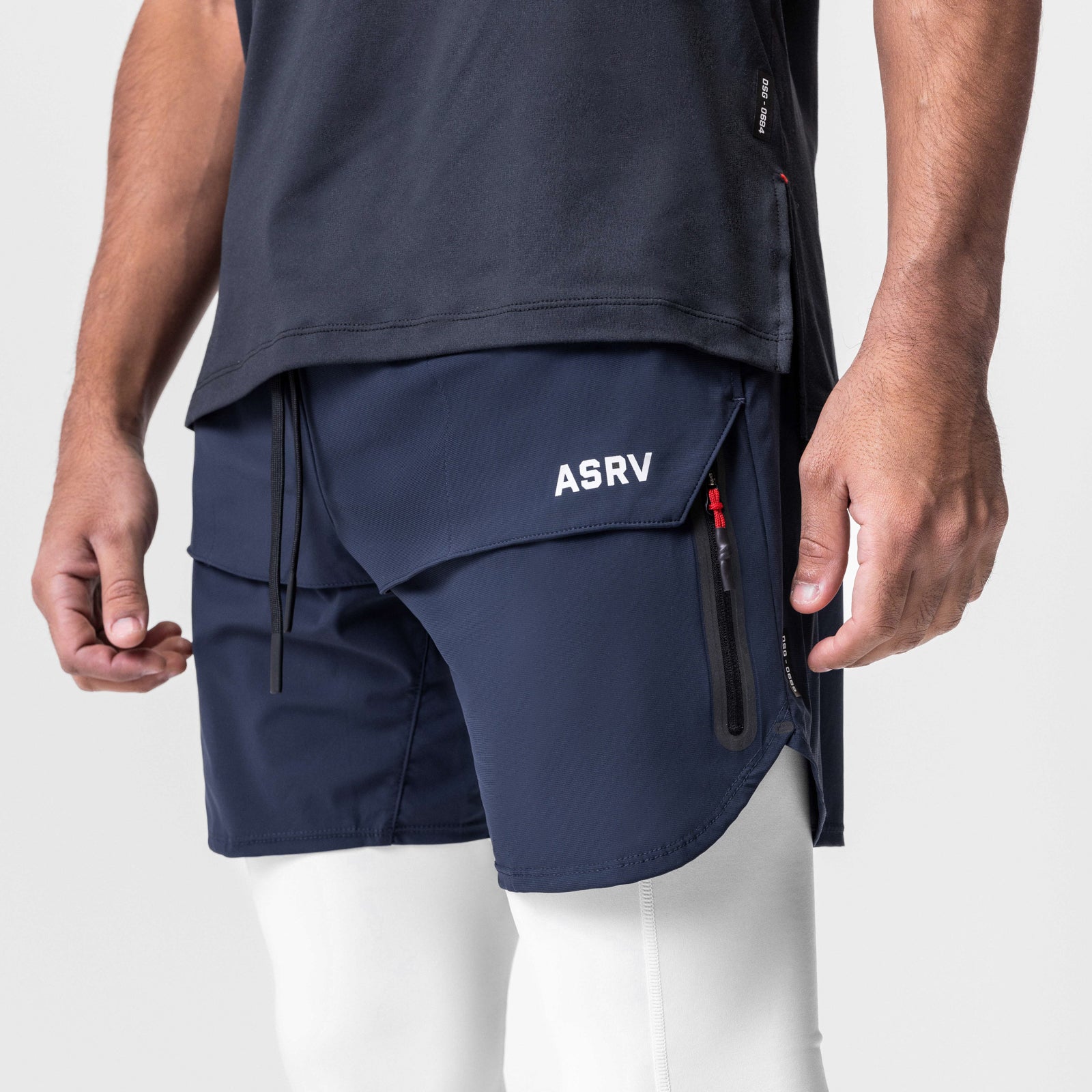 Tetra-Lite Tech Short in navy, worn by model with white leggings, side view