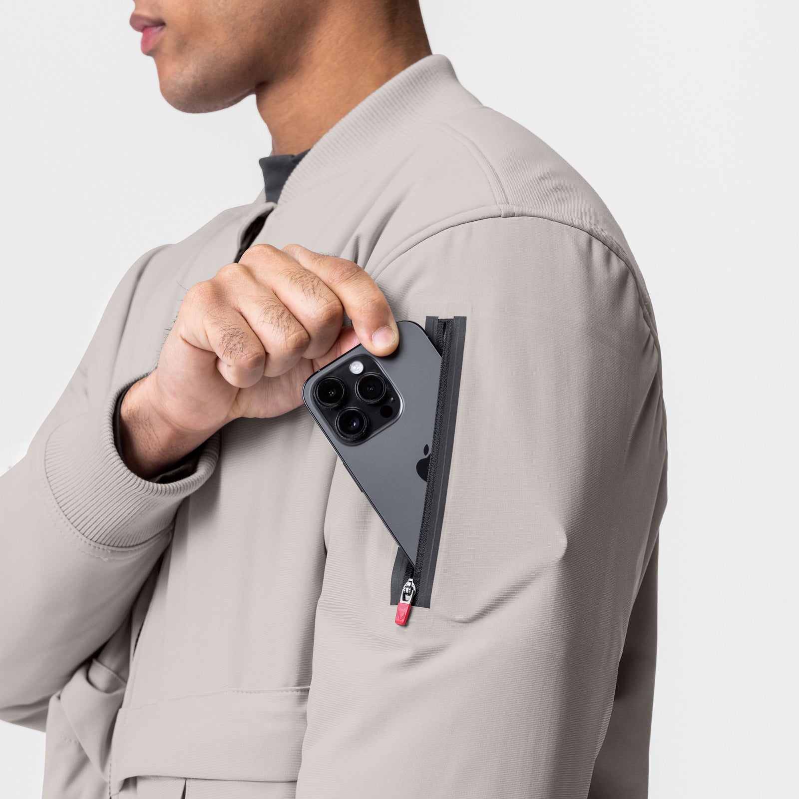 Kinterra Weatherproof Bomber Jacket in Chai, worn by model pulling phone from chest pocket