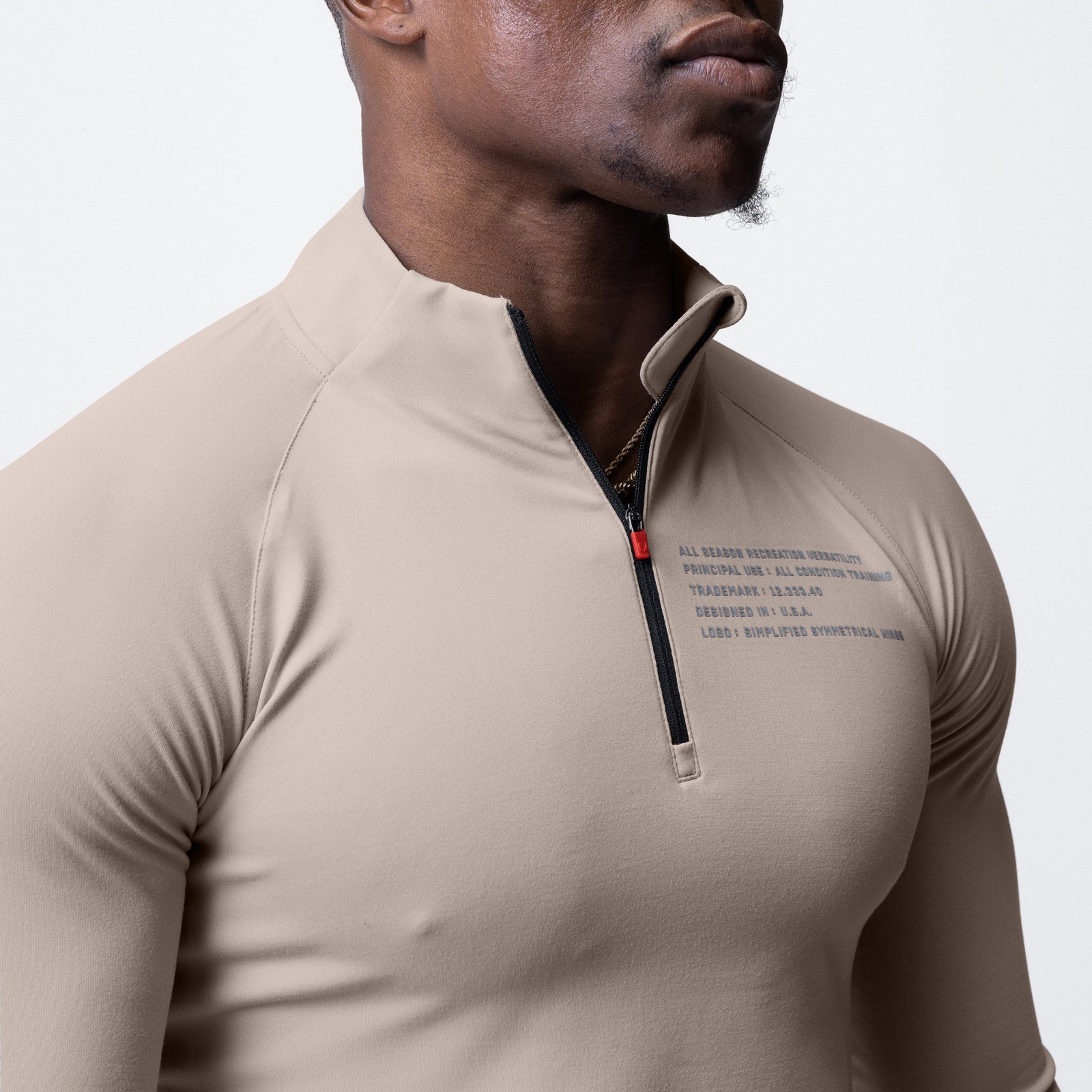 Core Fitted Quarter Zip in chai, worn by model, front view showing chest graphic and zipper detail