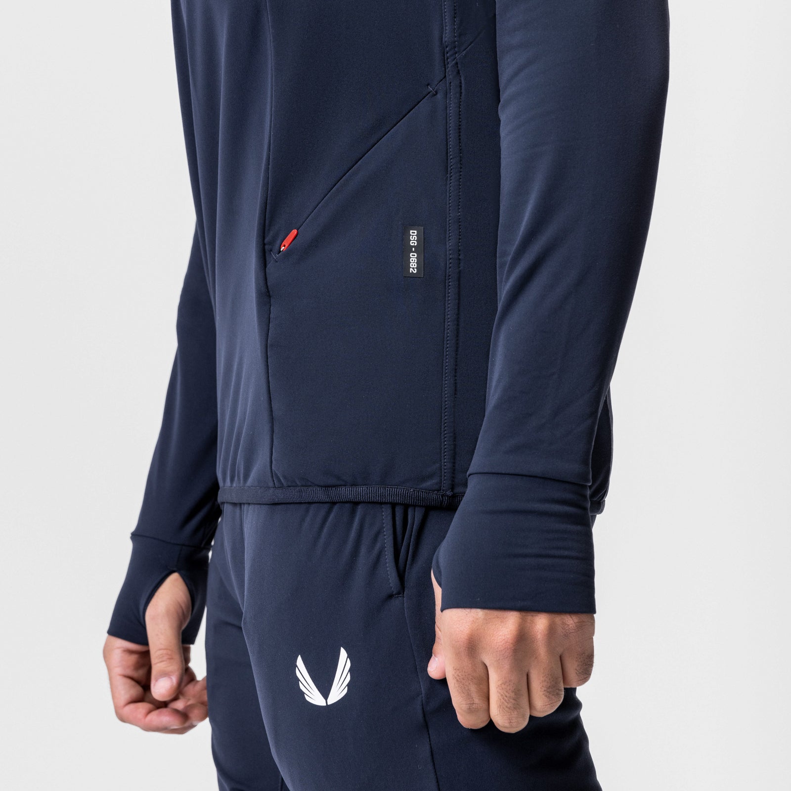 Training Hoodie in navy worn by model, side detail view showing pocket and wing logo