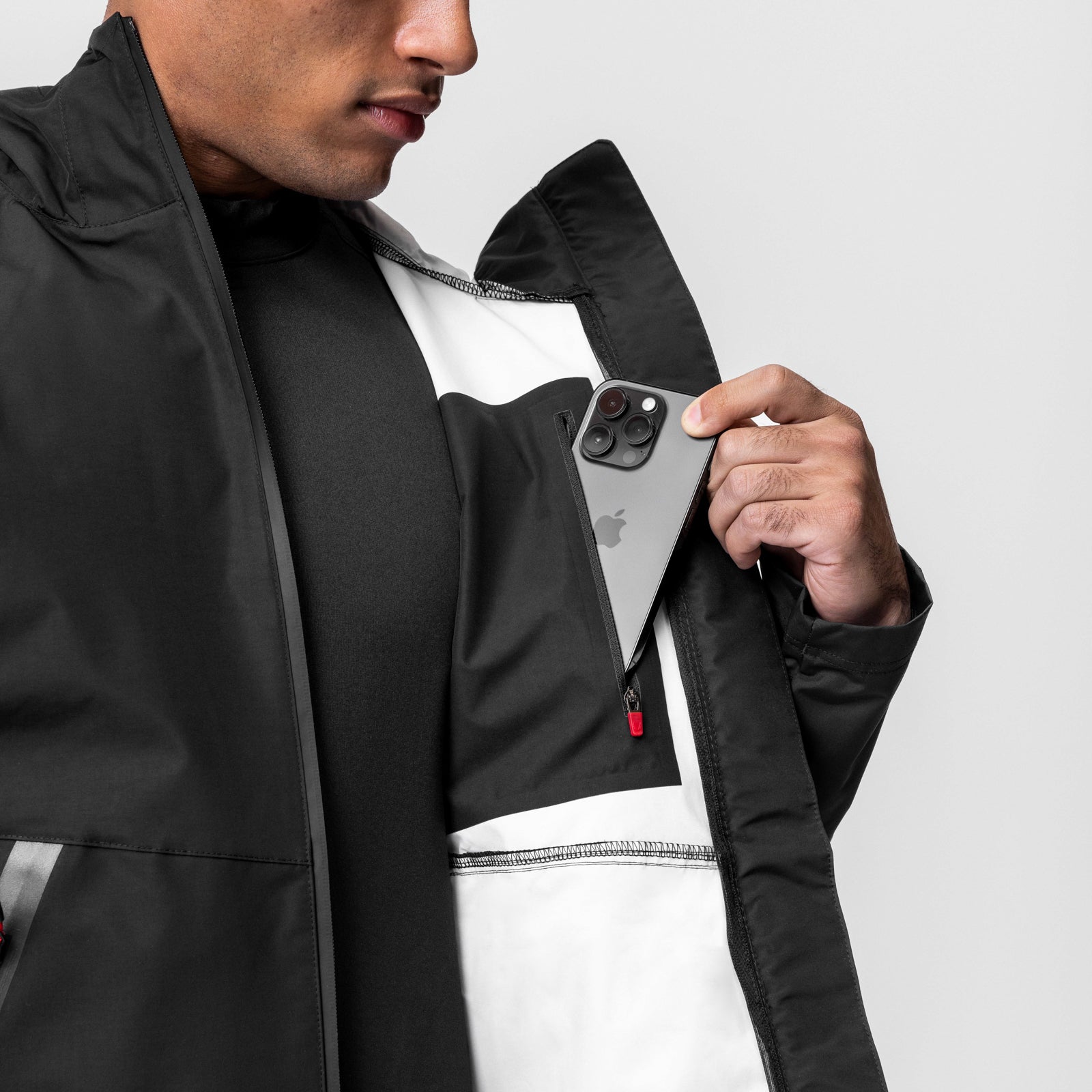 Black Hipora® Tech Parka worn by model, displaying interior pocket with phone
