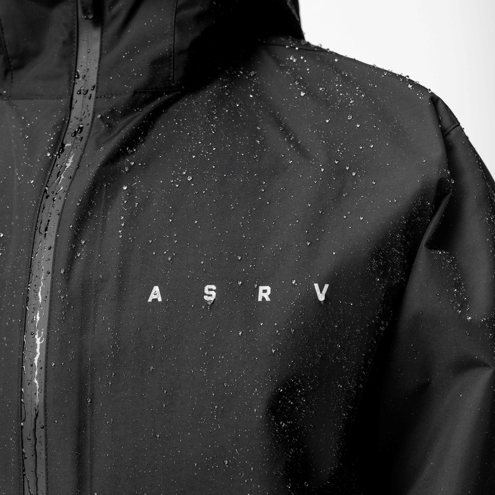 Hipora® Tech Parka in black worn by model, wet with water droplets, front view