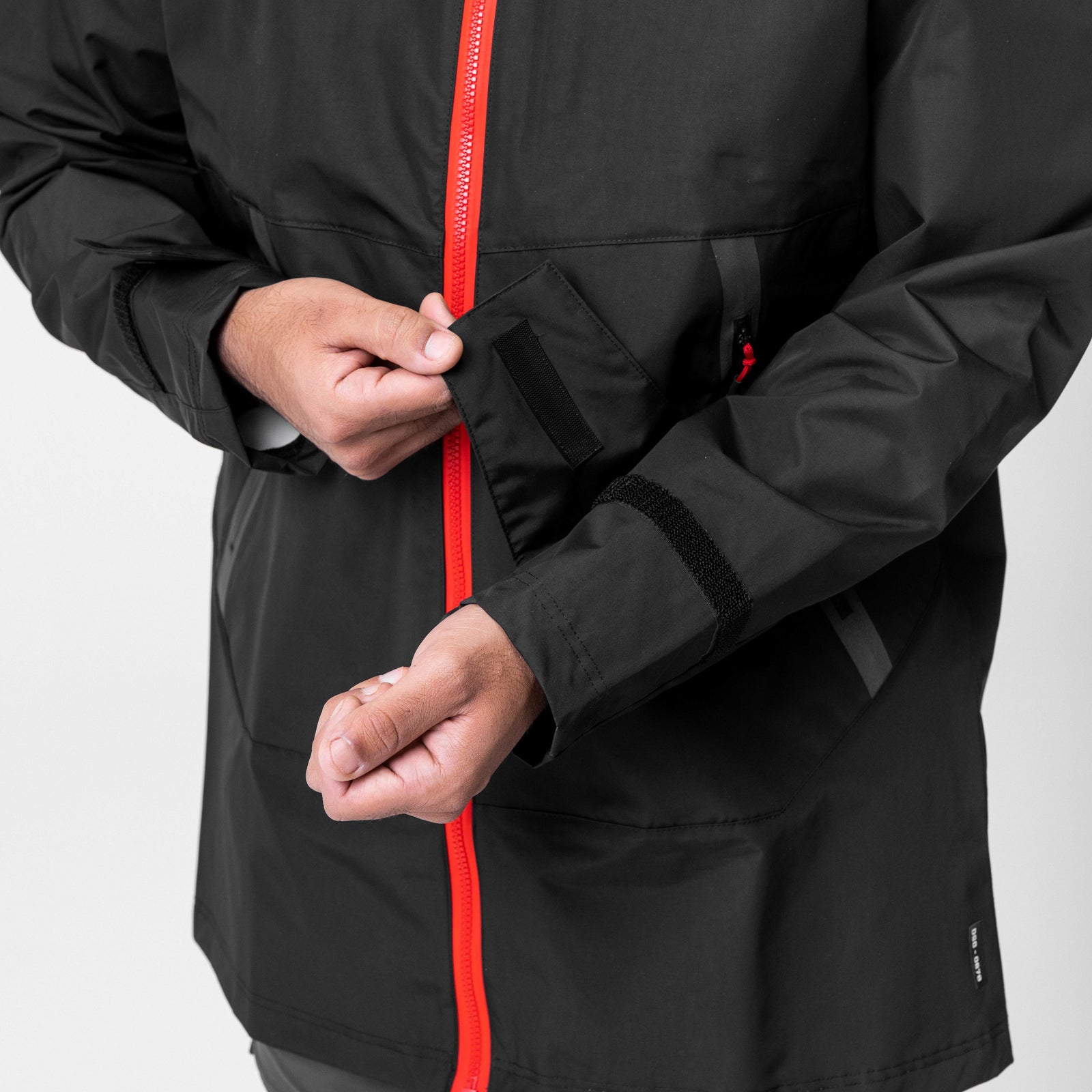 Black Hipora AQUAzip Tech Parka worn by model, front view with red zip detail