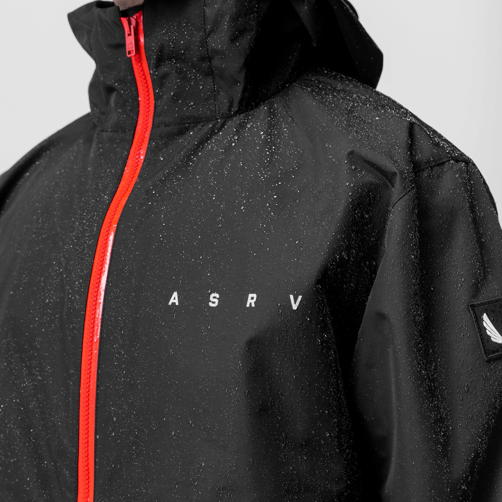 Black Hipora AQUAzip Tech Parka with red zipper on model, front view
