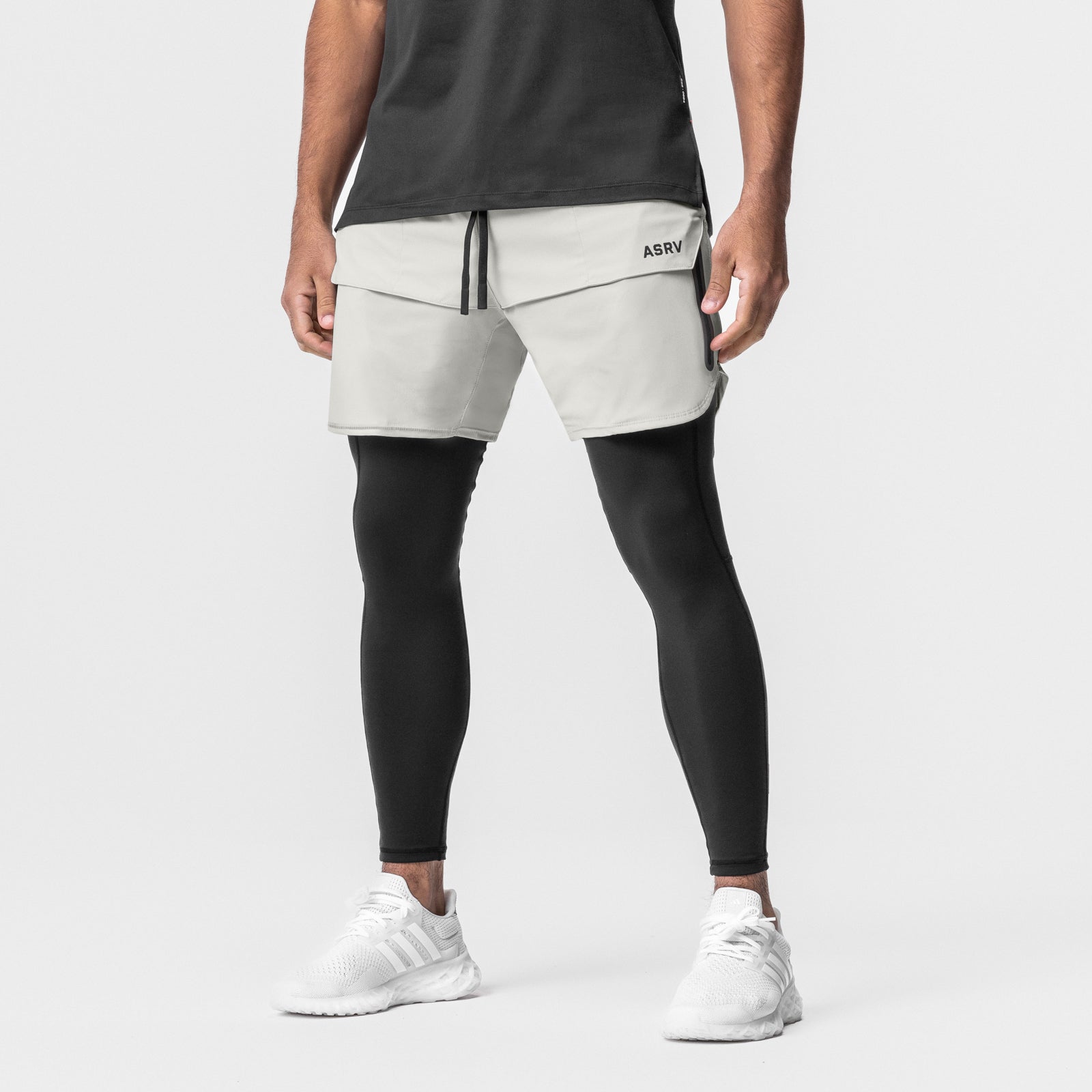 Tetra-Lite 7" Tech Short in stone worn with black leggings and white sneakers, front view