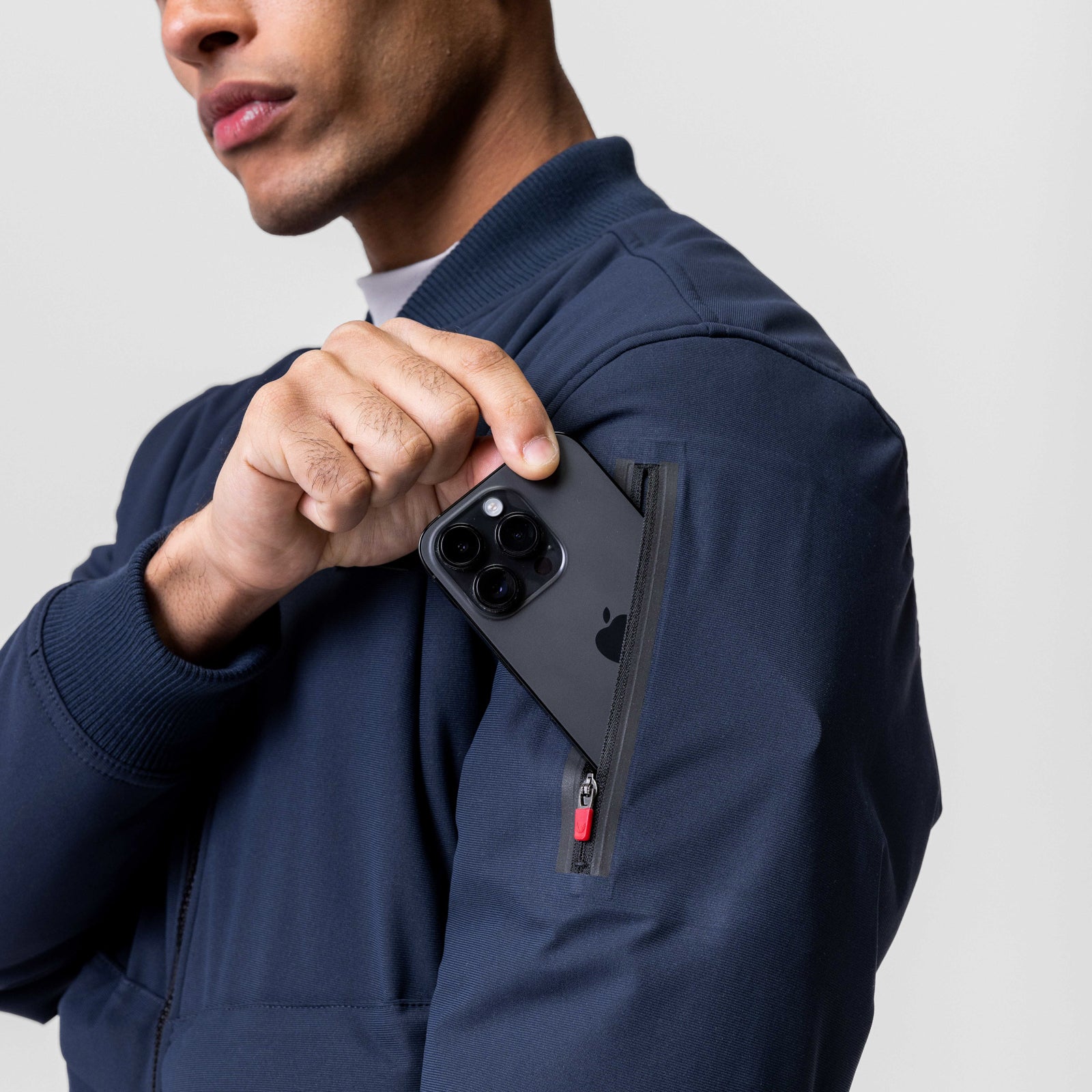Kinterra Weatherproof Bomber Jacket in navy, worn by model holding phone in jacket pocket