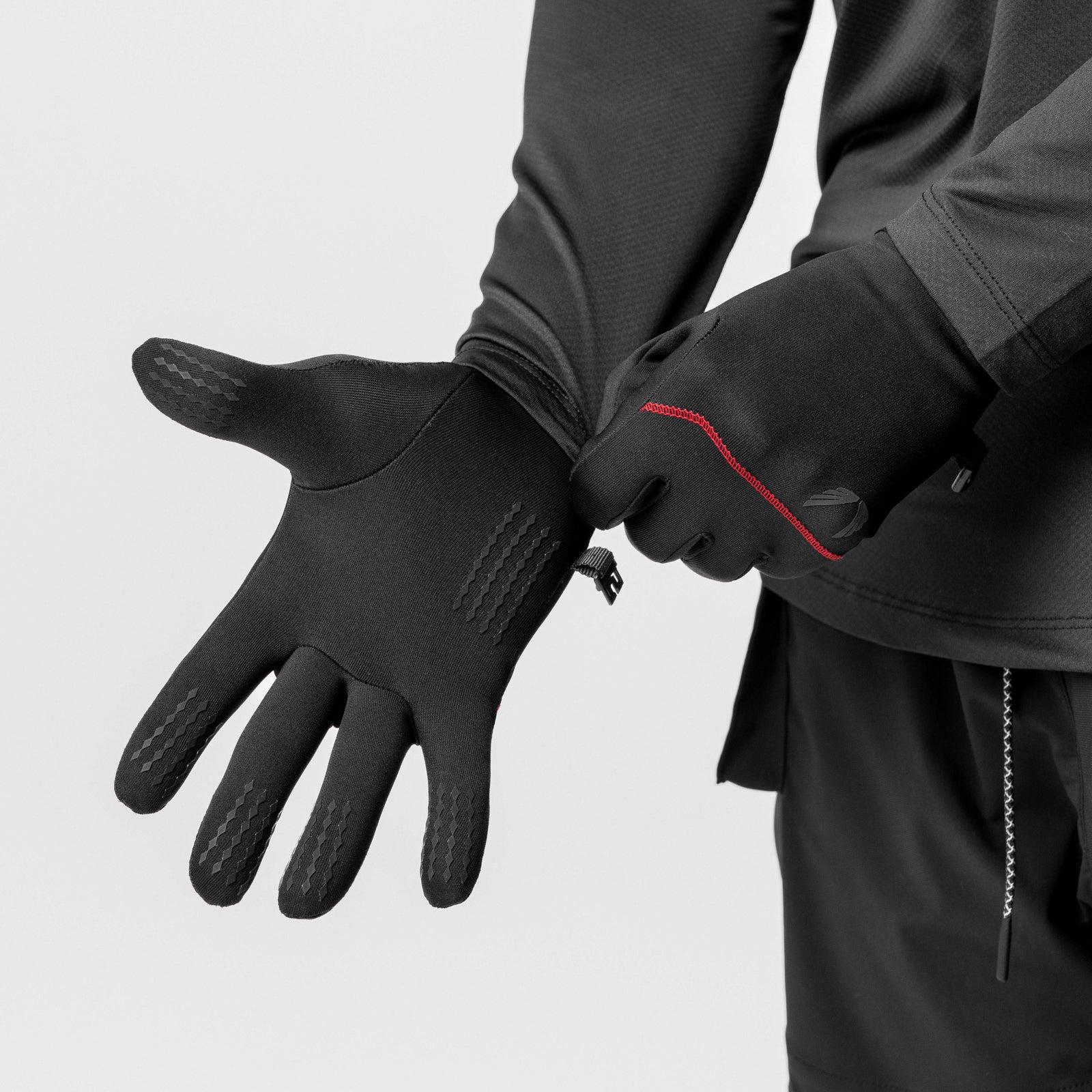 Aeroheat Lightweight Gloves in black with red accent, being put on by model