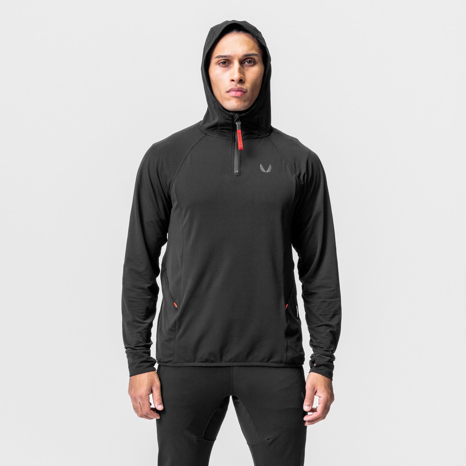 Black training hoodie with hood up, worn by male model standing against white background