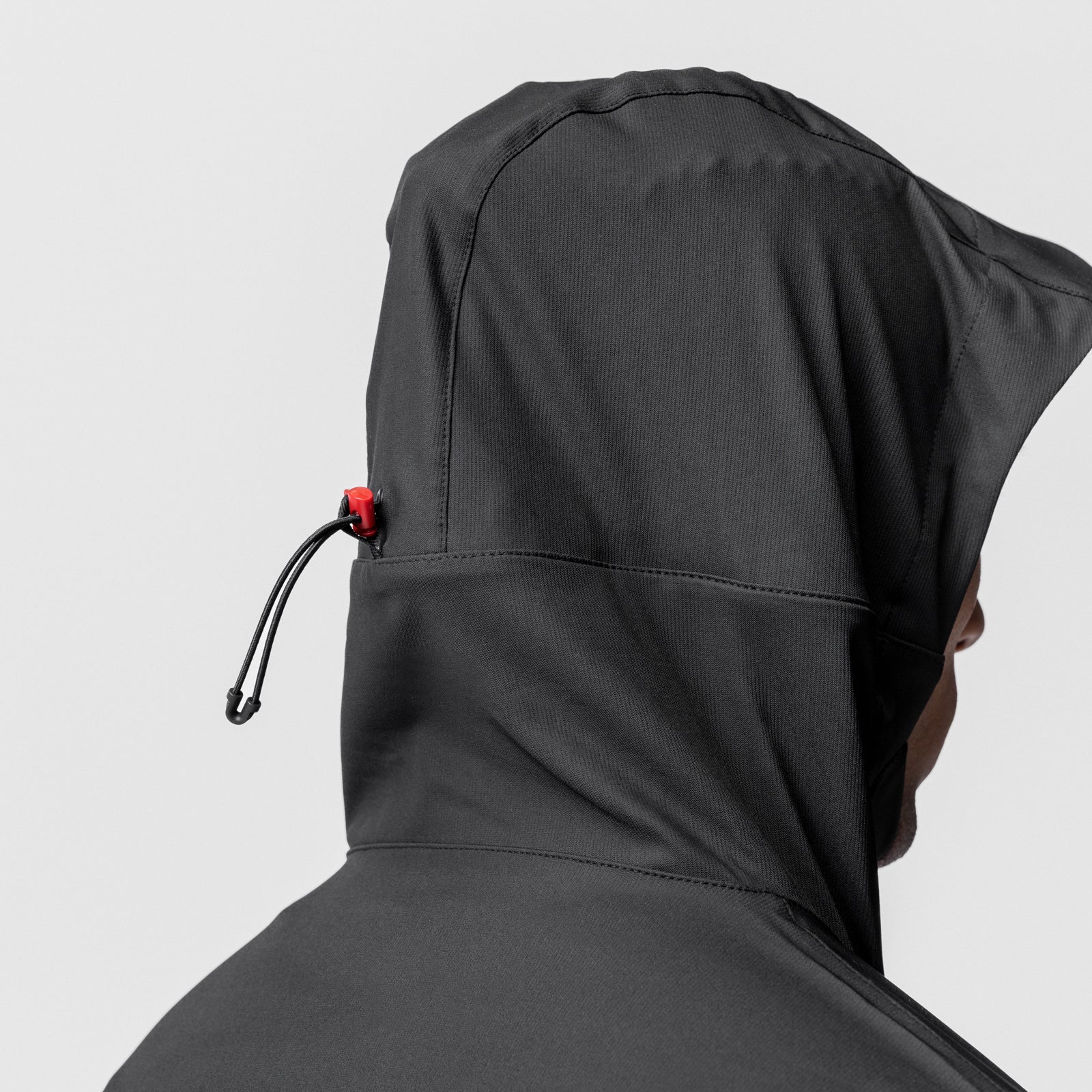 Black weather-ready anorak jacket on model, rear hood view