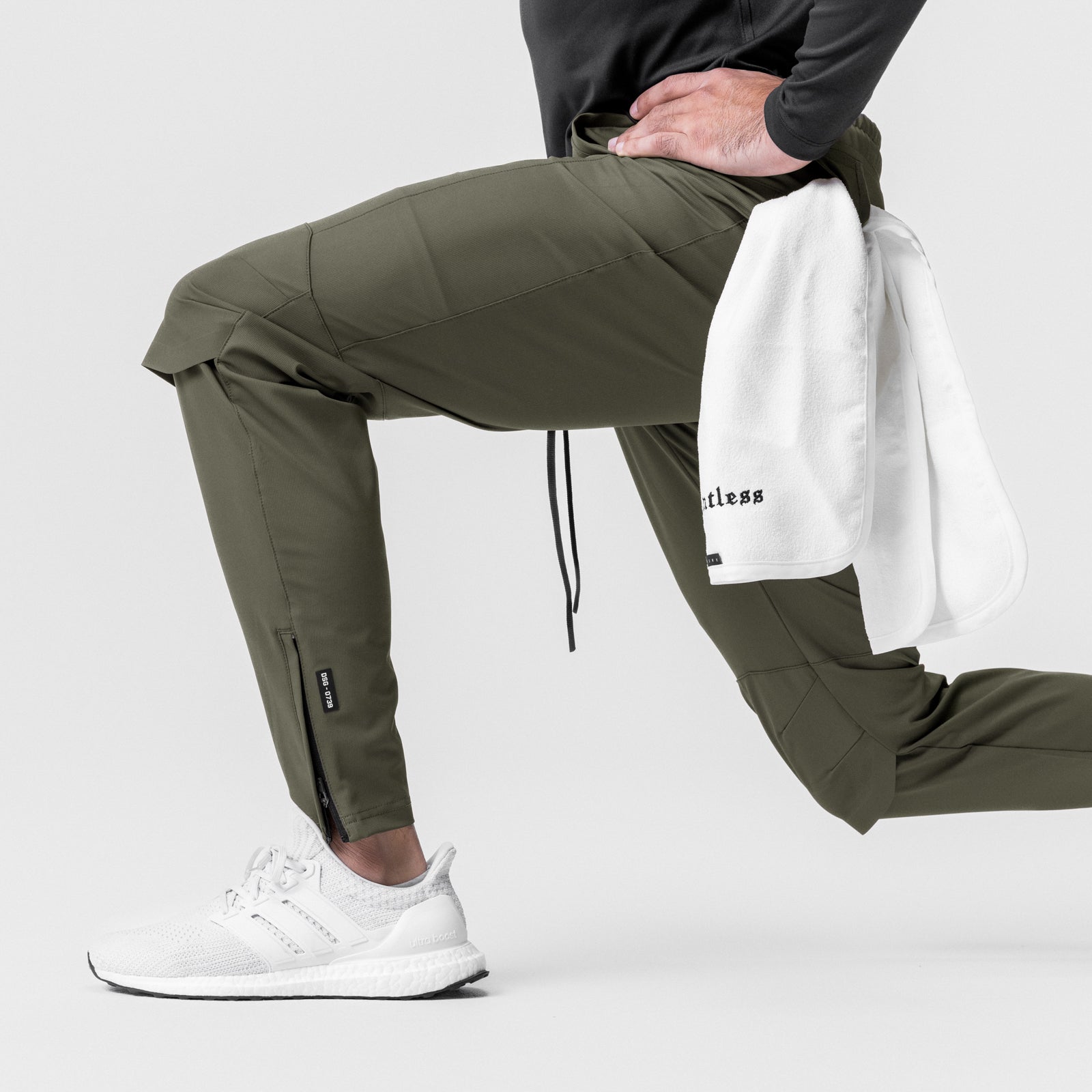 All Condition Moto Jogger in olive worn by model with white sneakers and towel