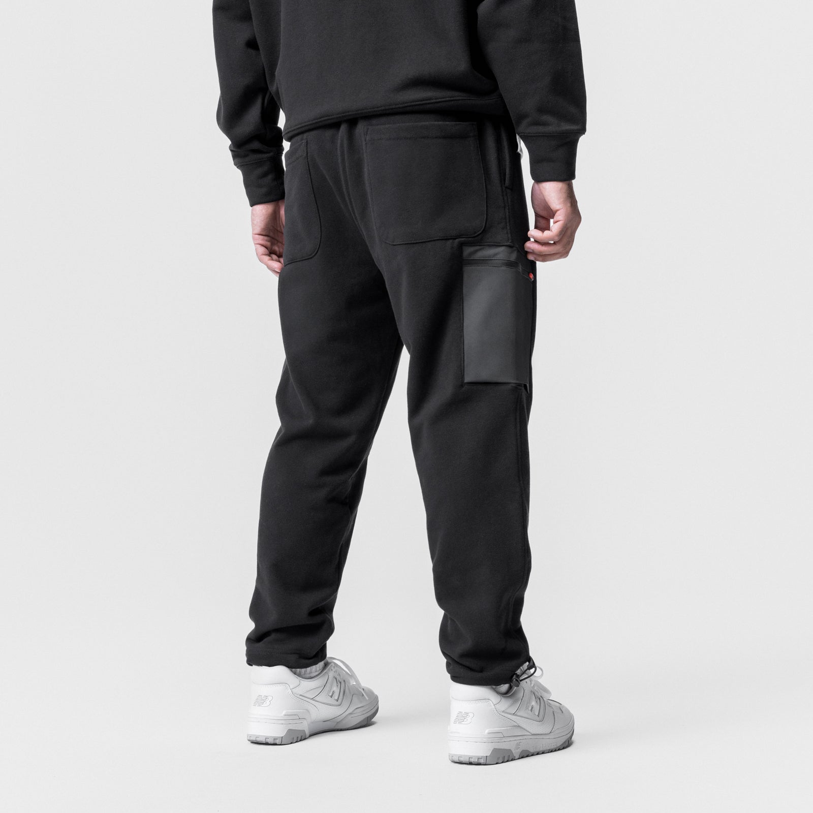 Black Tech-Terry Cinch Cargo Jogger worn by model, back view with white sneakers
