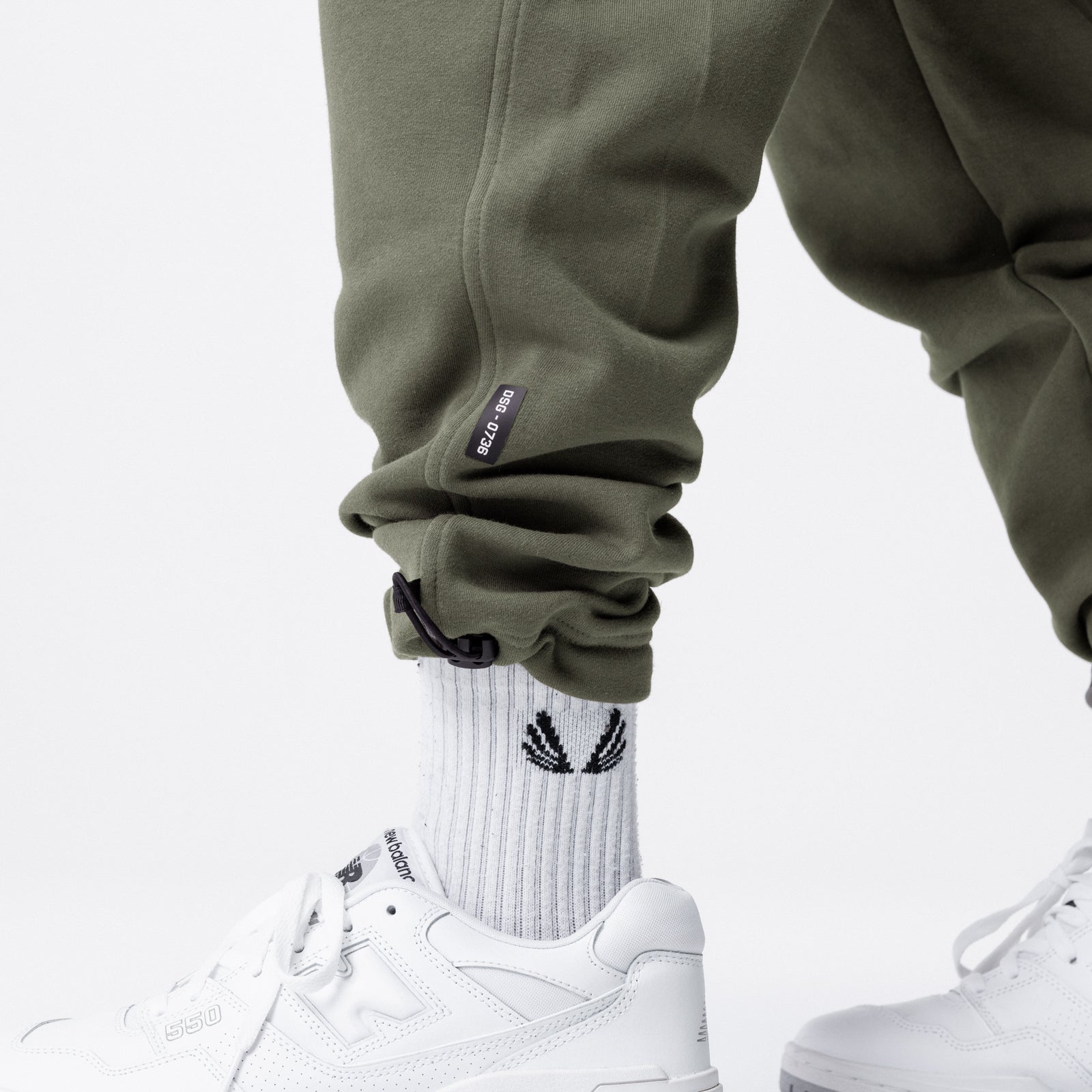 Tech-Terry Cinch Cargo Jogger in olive worn with white socks and sneakers, cropped leg view