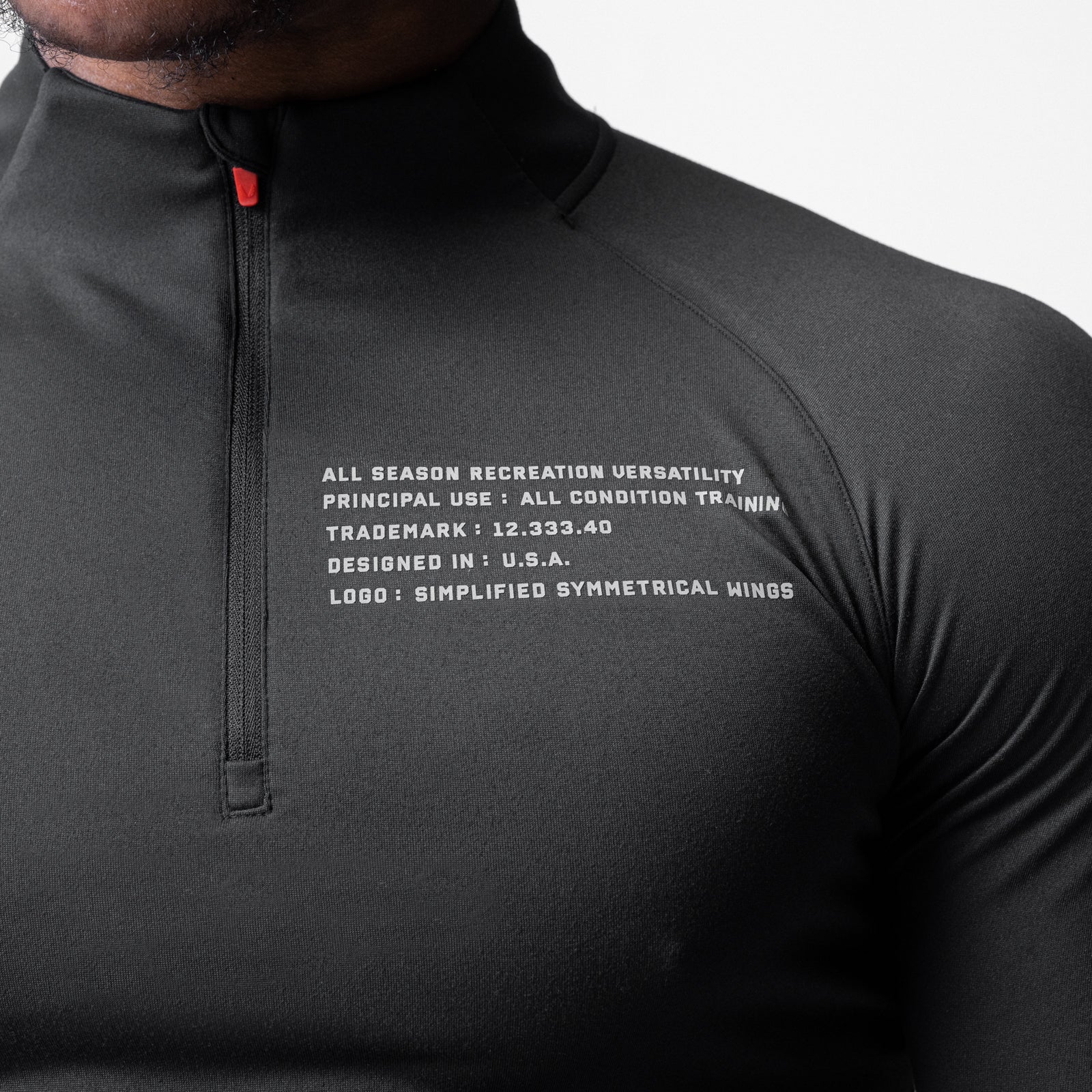 Core Fitted Quarter Zip in black worn by model, chest detail view showing text graphic
