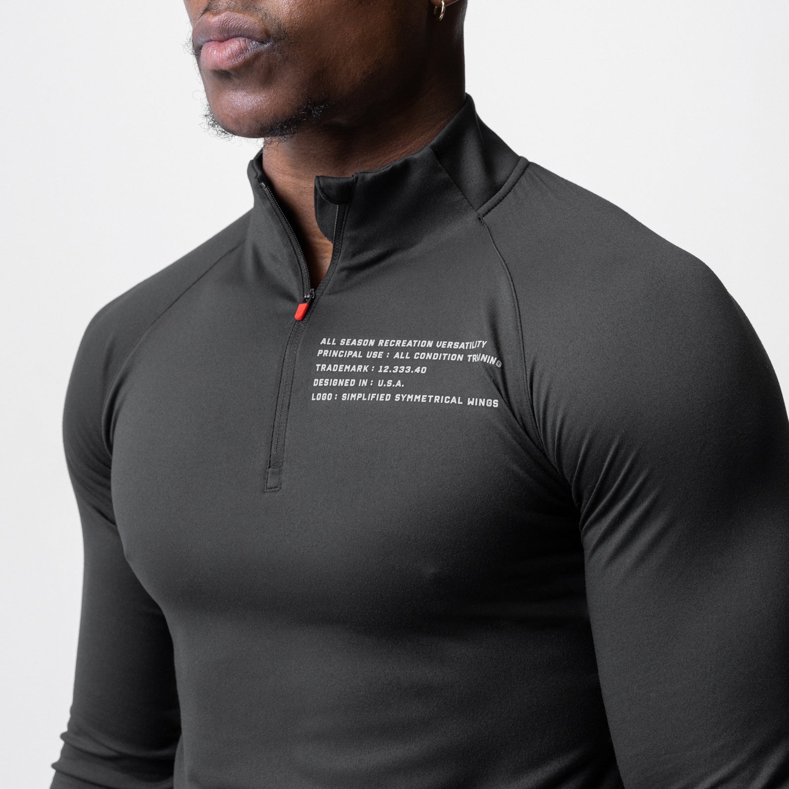 Core Fitted Quarter Zip in black, worn by model, front view showing chest text detail