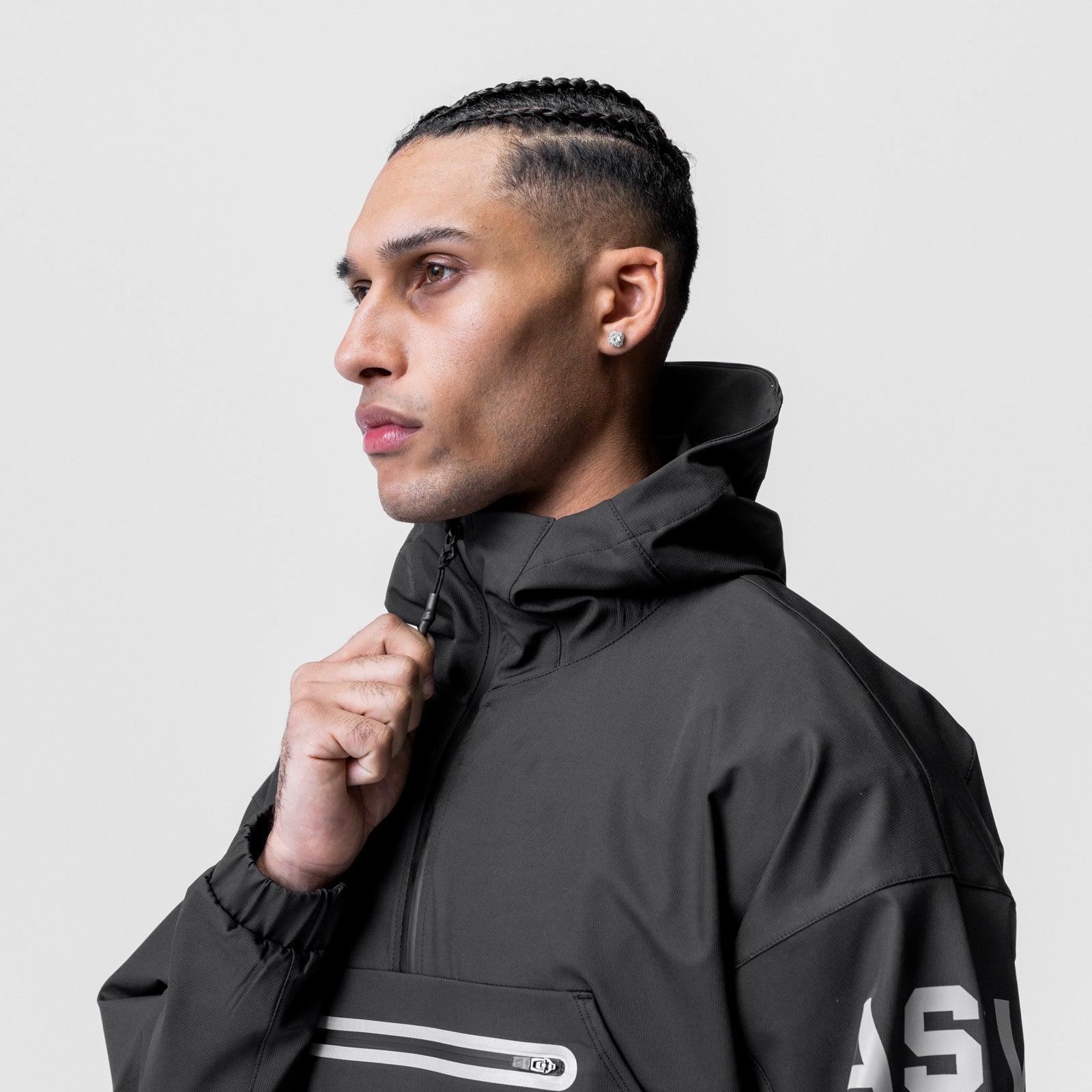 Black weather-ready anorak jacket worn by model in profile, side view