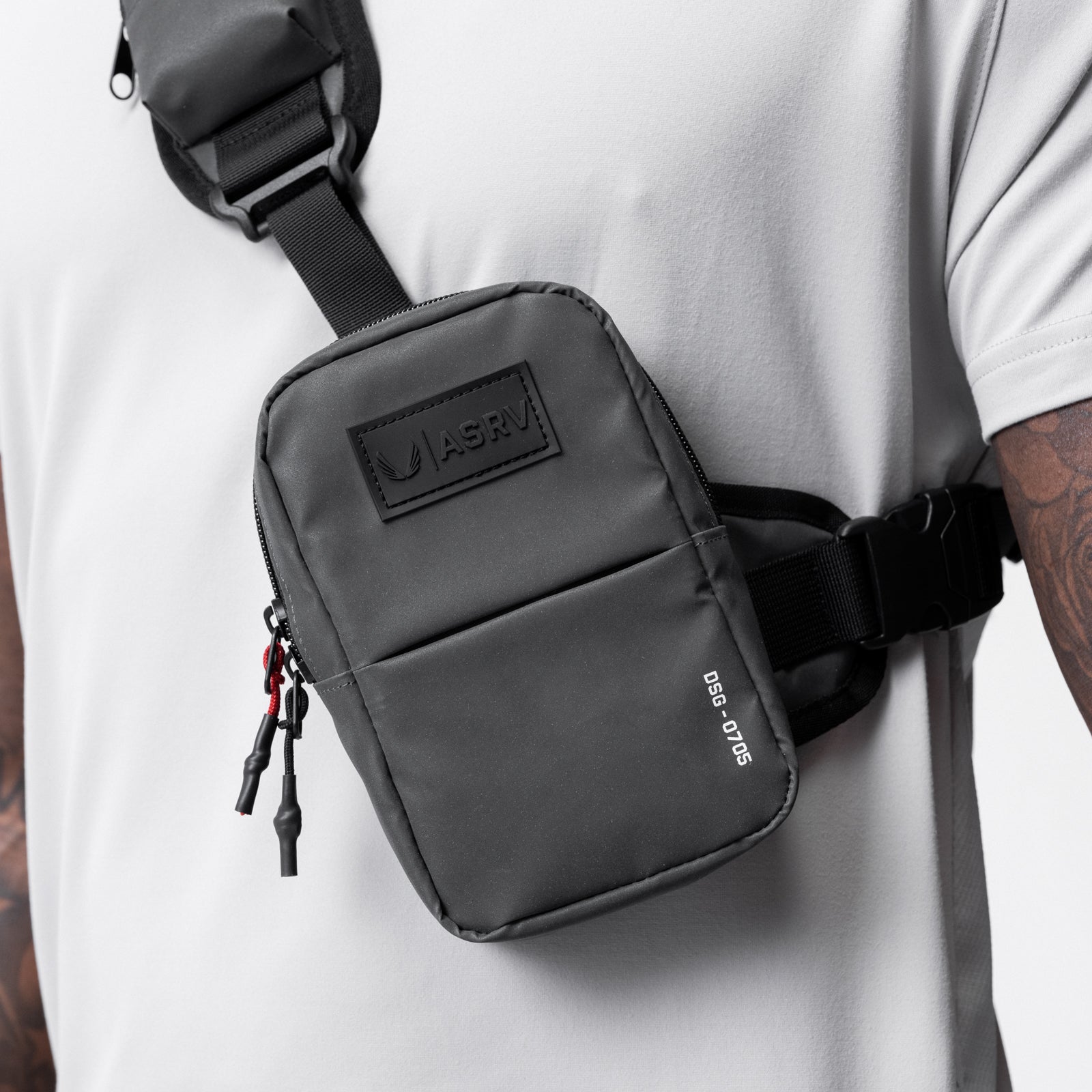 Reflective Holster Sling Bag in black, worn on model's side, front view