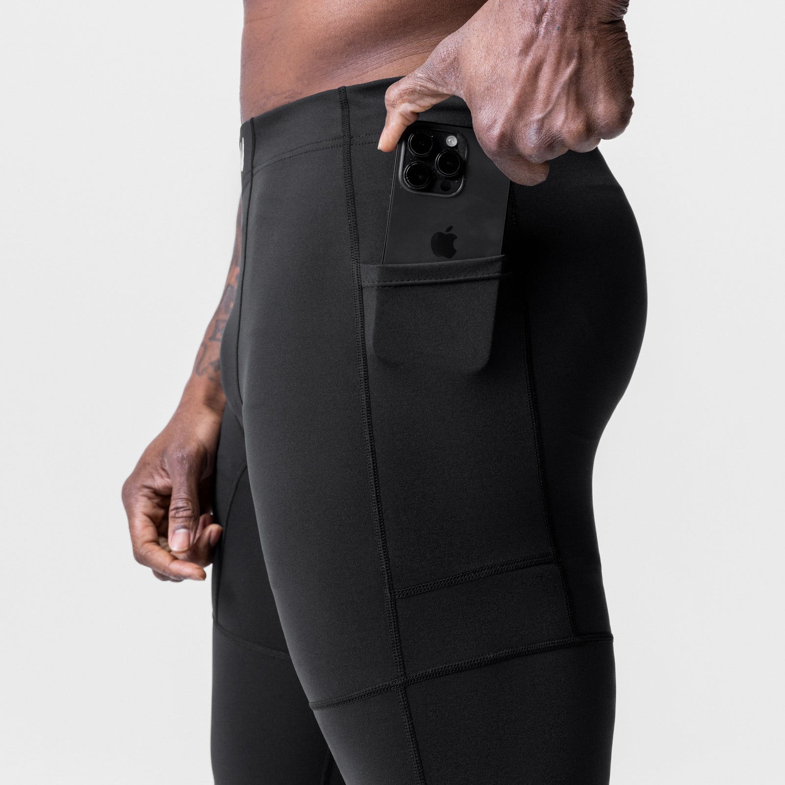 WarpFlexx® Side Pocket 3/4-Length Legging in black, model holding phone in side pocket, side view