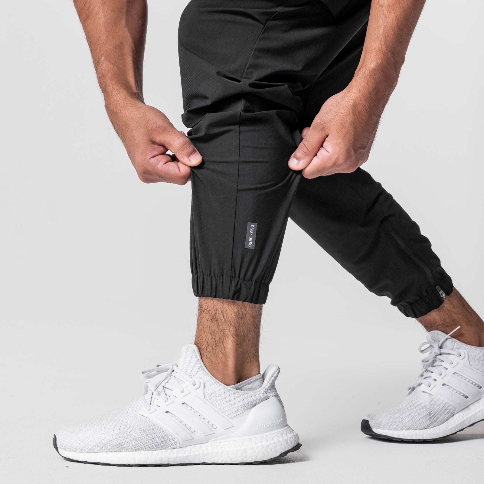 Black Tetra-Lite Standard Zip Jogger worn by model with white sneakers, front view