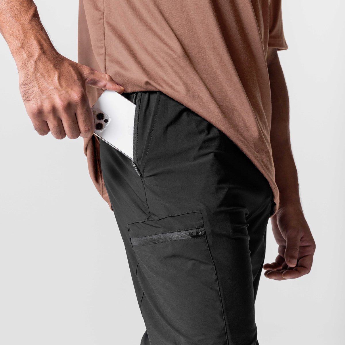 Tetra-Lite Standard Zip Jogger in black, worn by model holding smartphone in cargo pocket