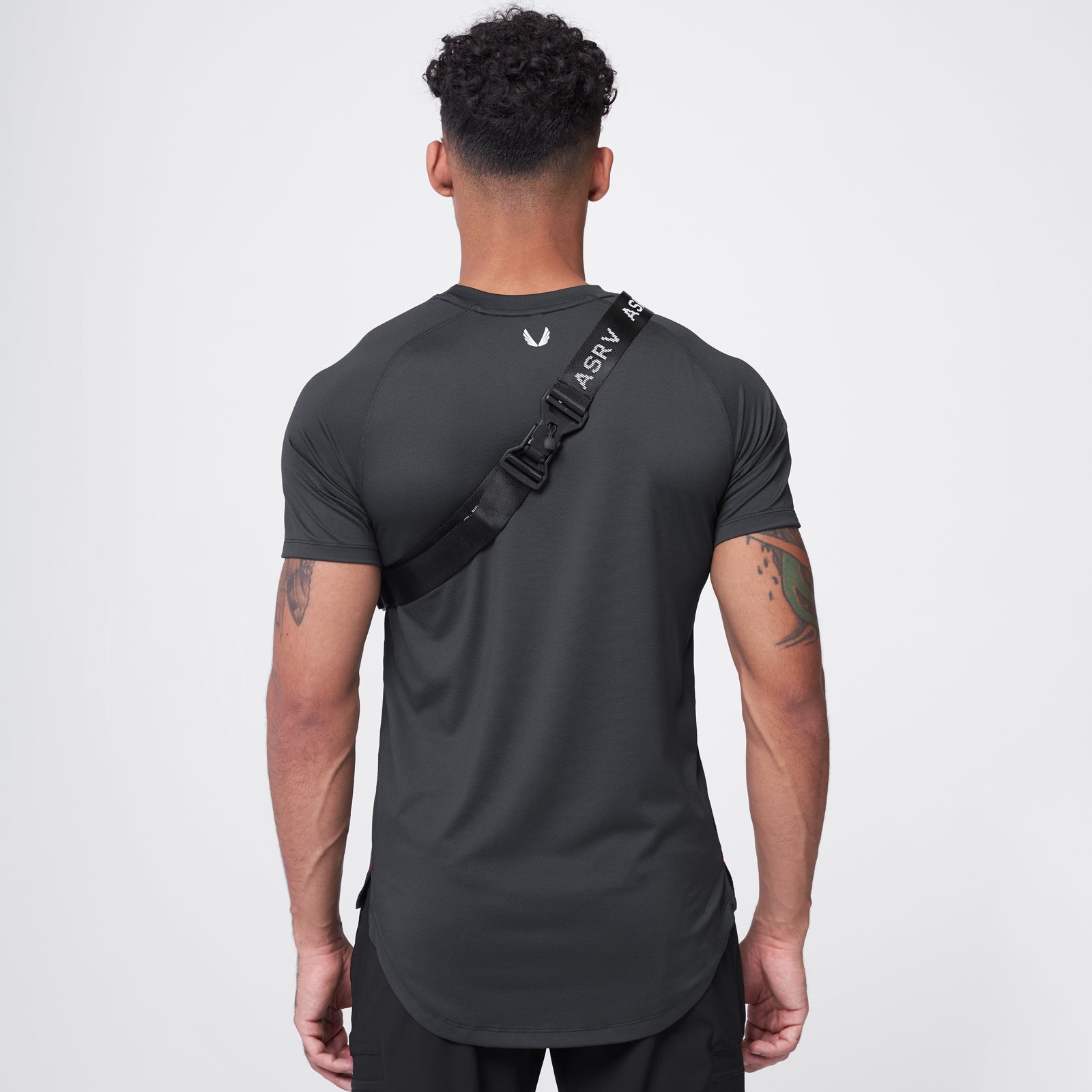Small Crossbody Bag in black, worn across chest on male model, back view
