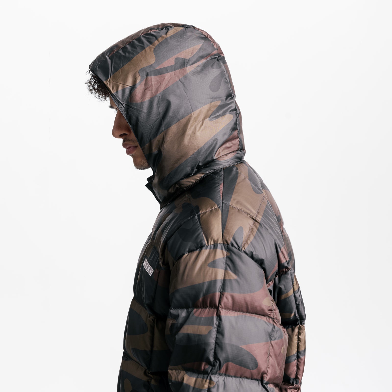 Weather-Ready Down Puffer Jacket in rust camo, worn by model in profile view with hood up