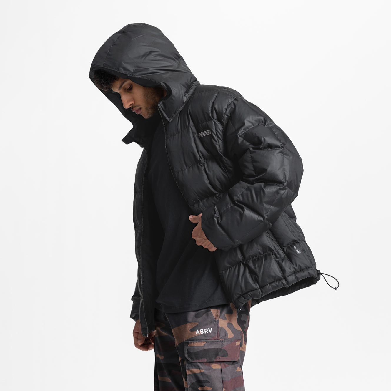 Black weather-ready down puffer jacket worn by model with hood up, side view