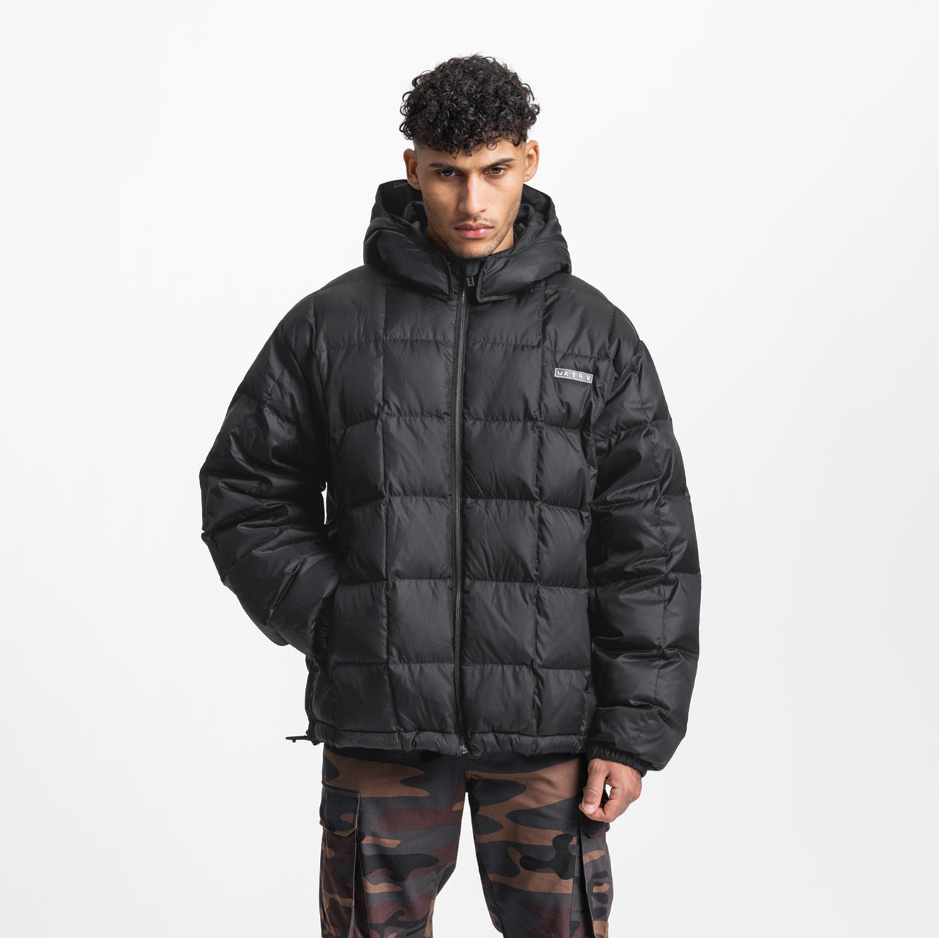 Black weather-ready down puffer jacket worn by model, front view