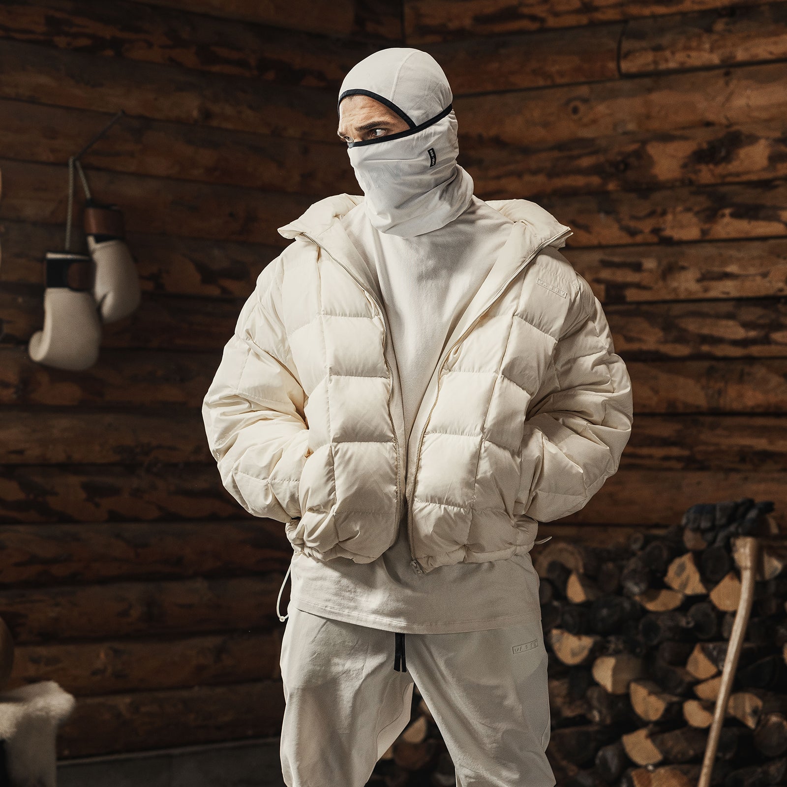Ivory cream down puffer jacket worn by model in rustic wooden cabin setting